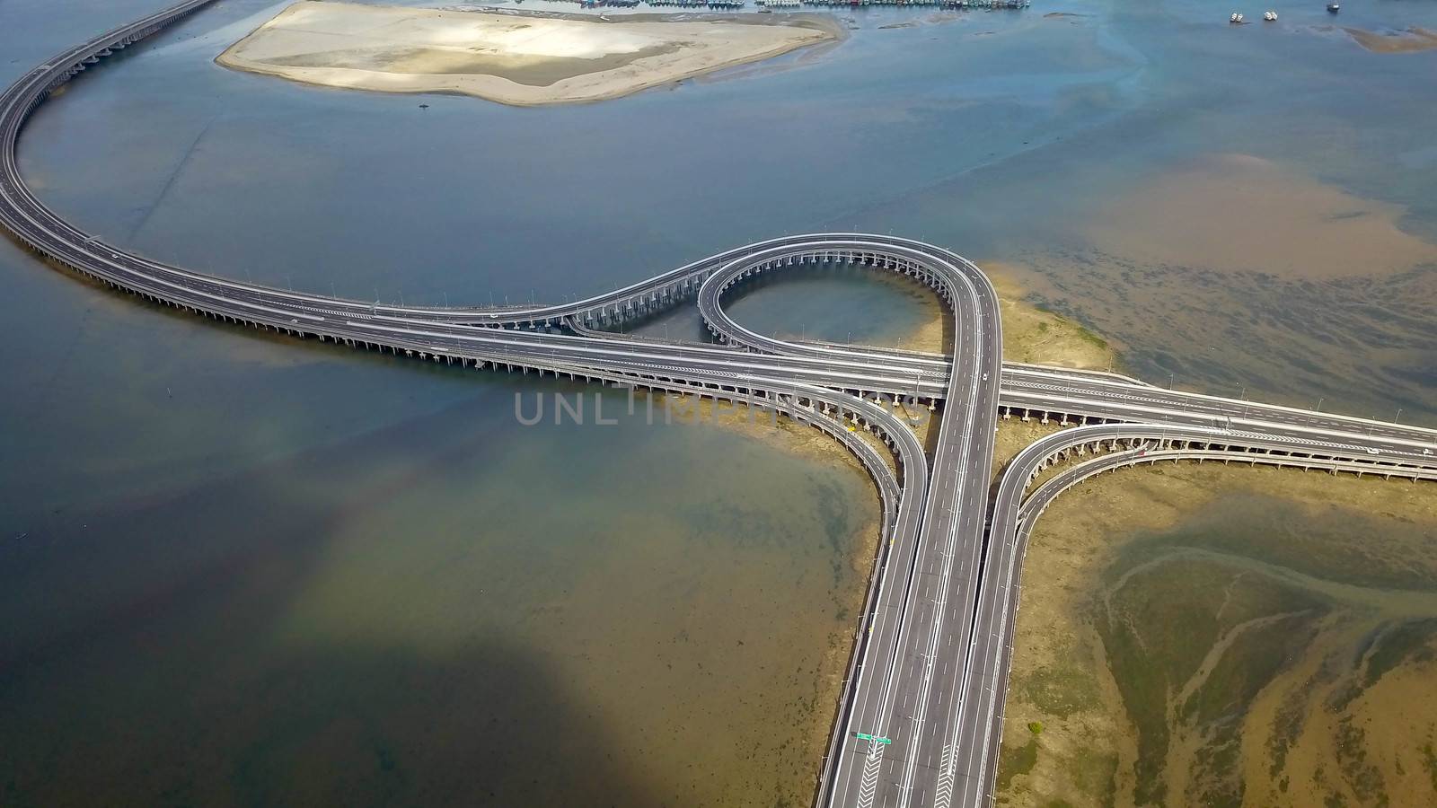 Aerial view of Bali Mandara toll road over sea on Bali island. Car, motorbike bridge across the Gulf of Benoa connecting Denpasar city and South Kuta, Nusa Dua and Ngurah Rai International Airport.