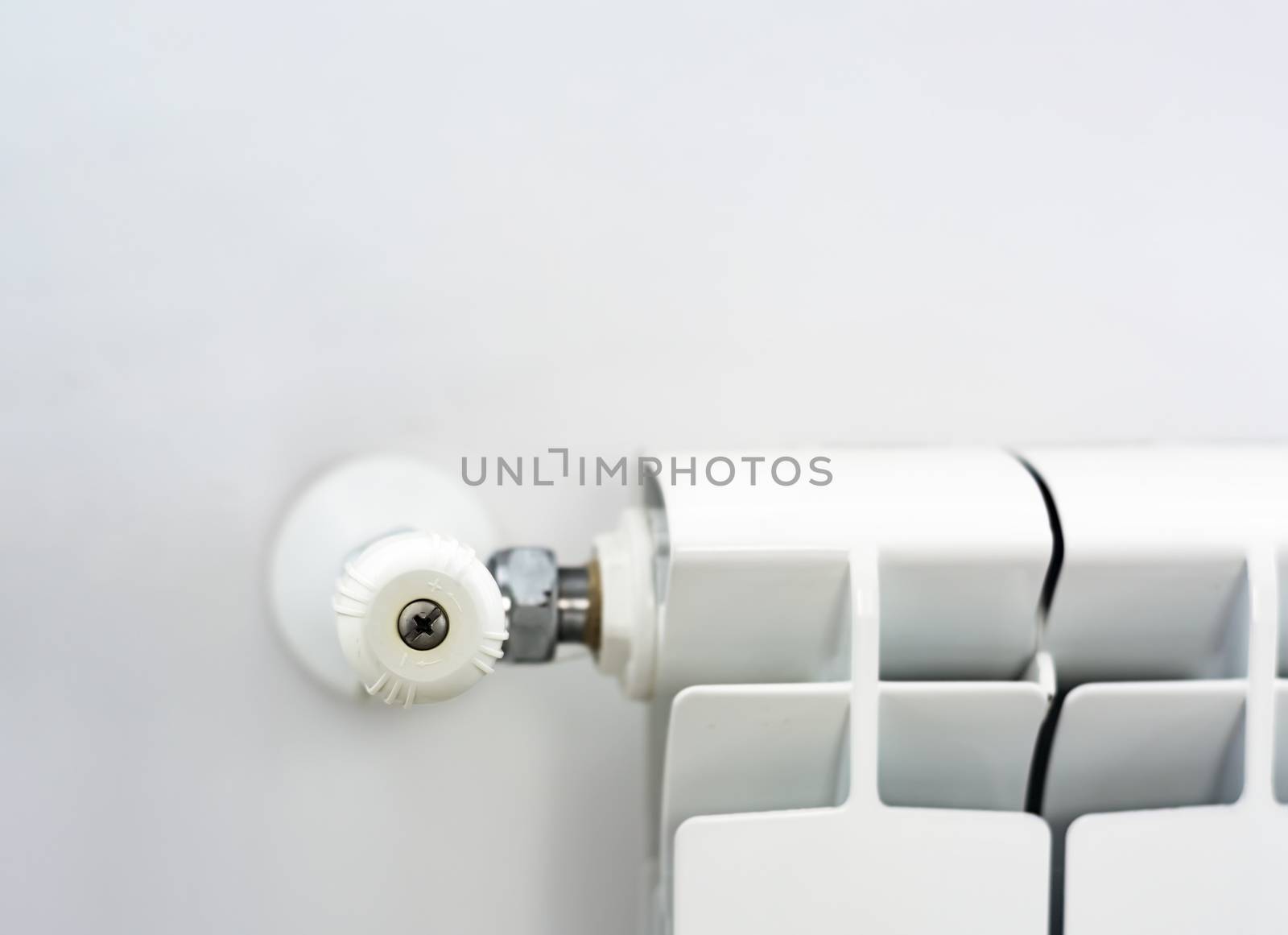 close-up view of the white knob that adjusts the temperature of the radiator by rarrarorro