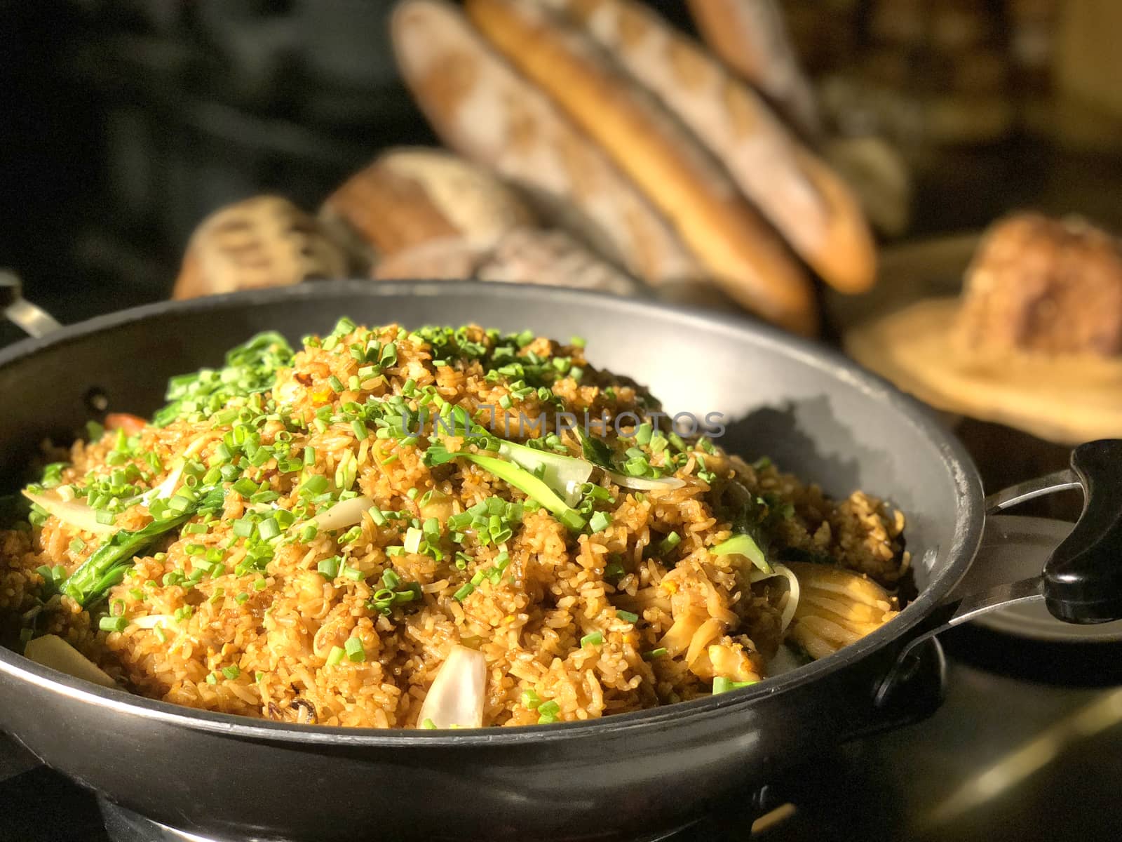 Garlic fried rice with vegetables on top and bread background by Surasak