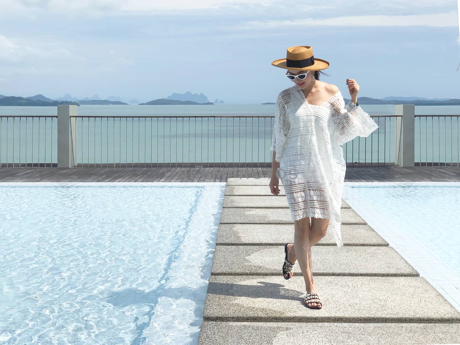 Summer holidays and vacation - Happy woman on the pool side in P by Surasak