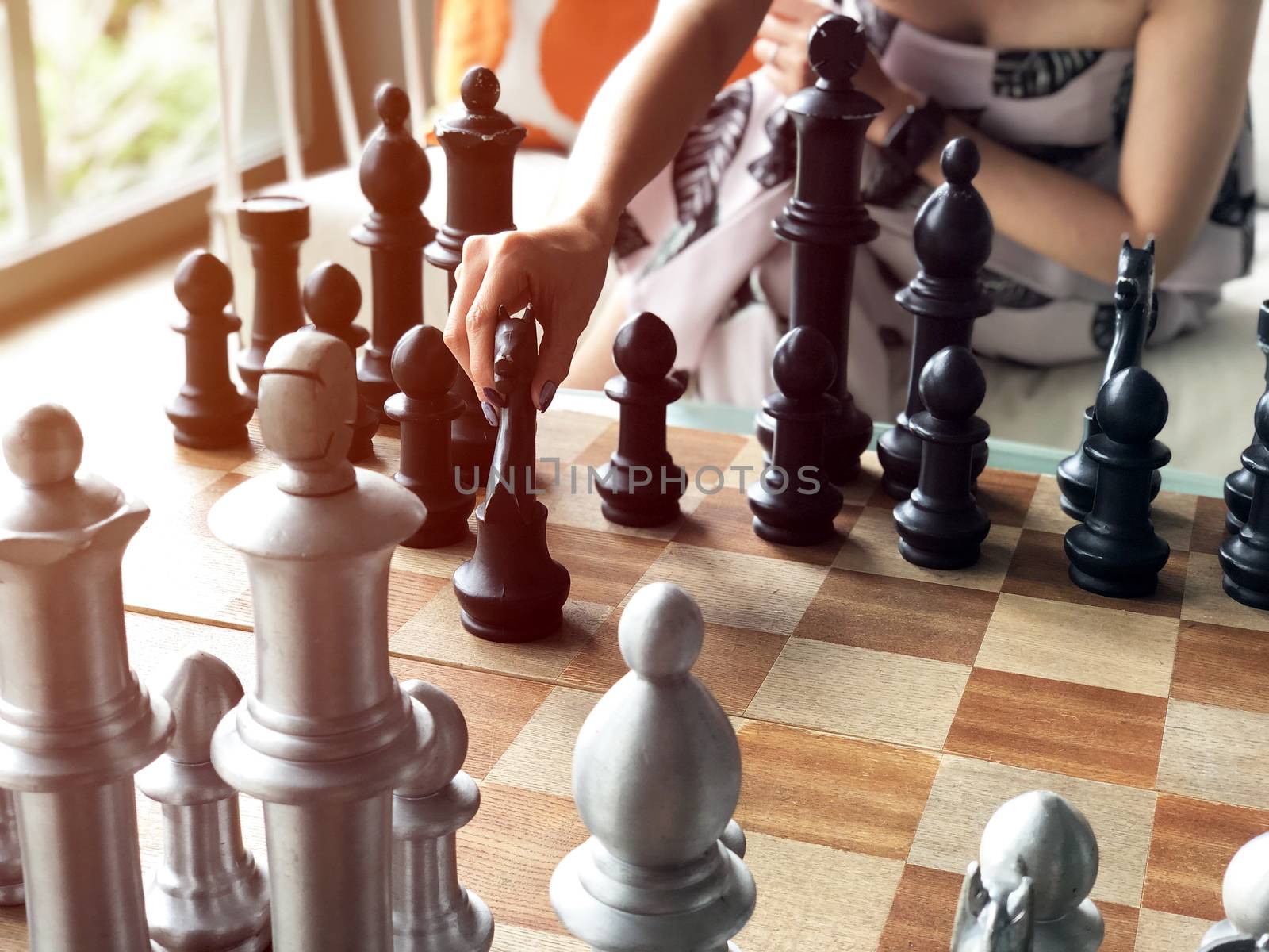 Close up of hands of young  woman playing chess. 