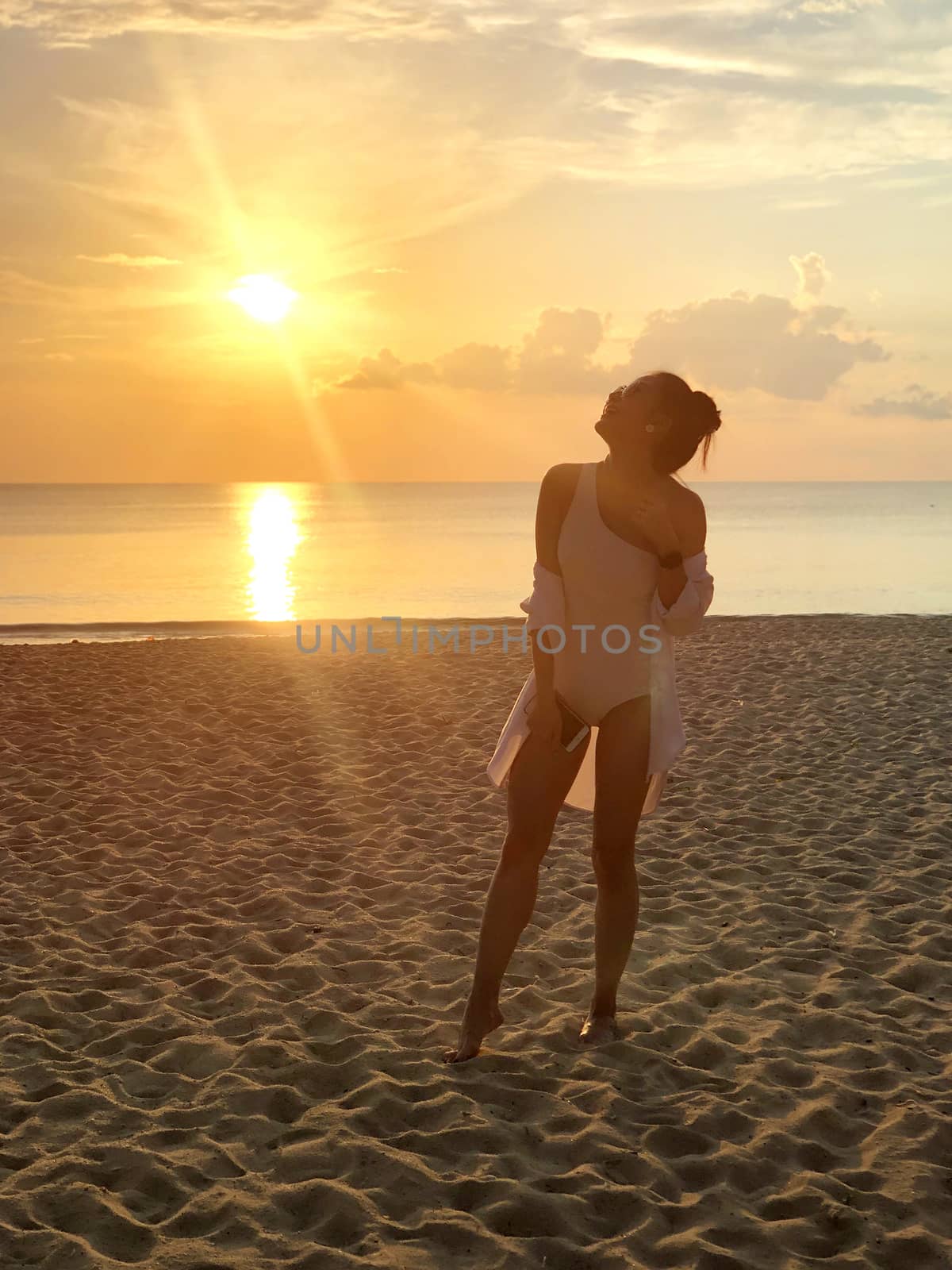 Happiness woman on beach. She is enjoying serene ocean nature su by Surasak