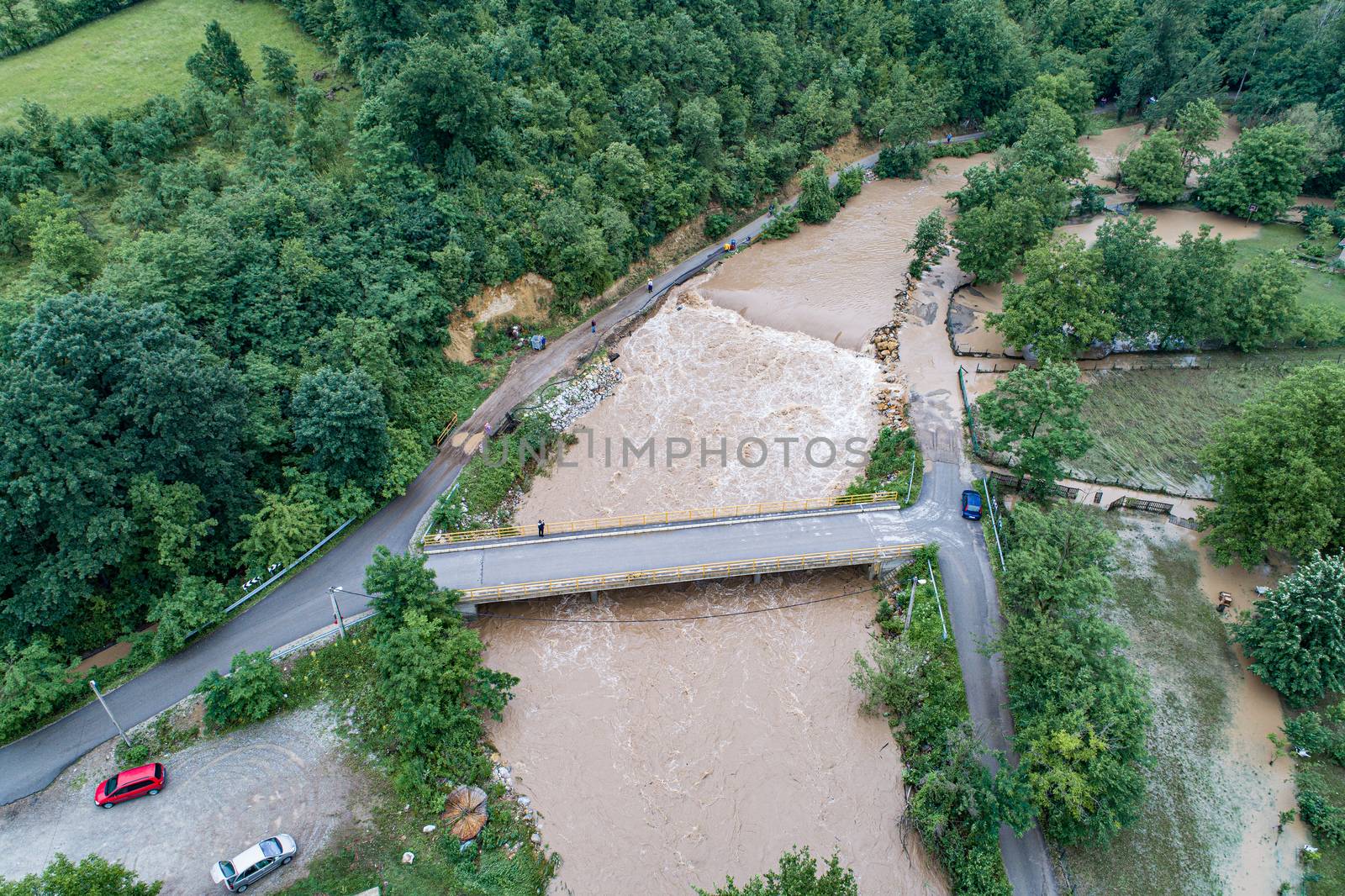 A river that overflows threatens the road bridge and property by adamr