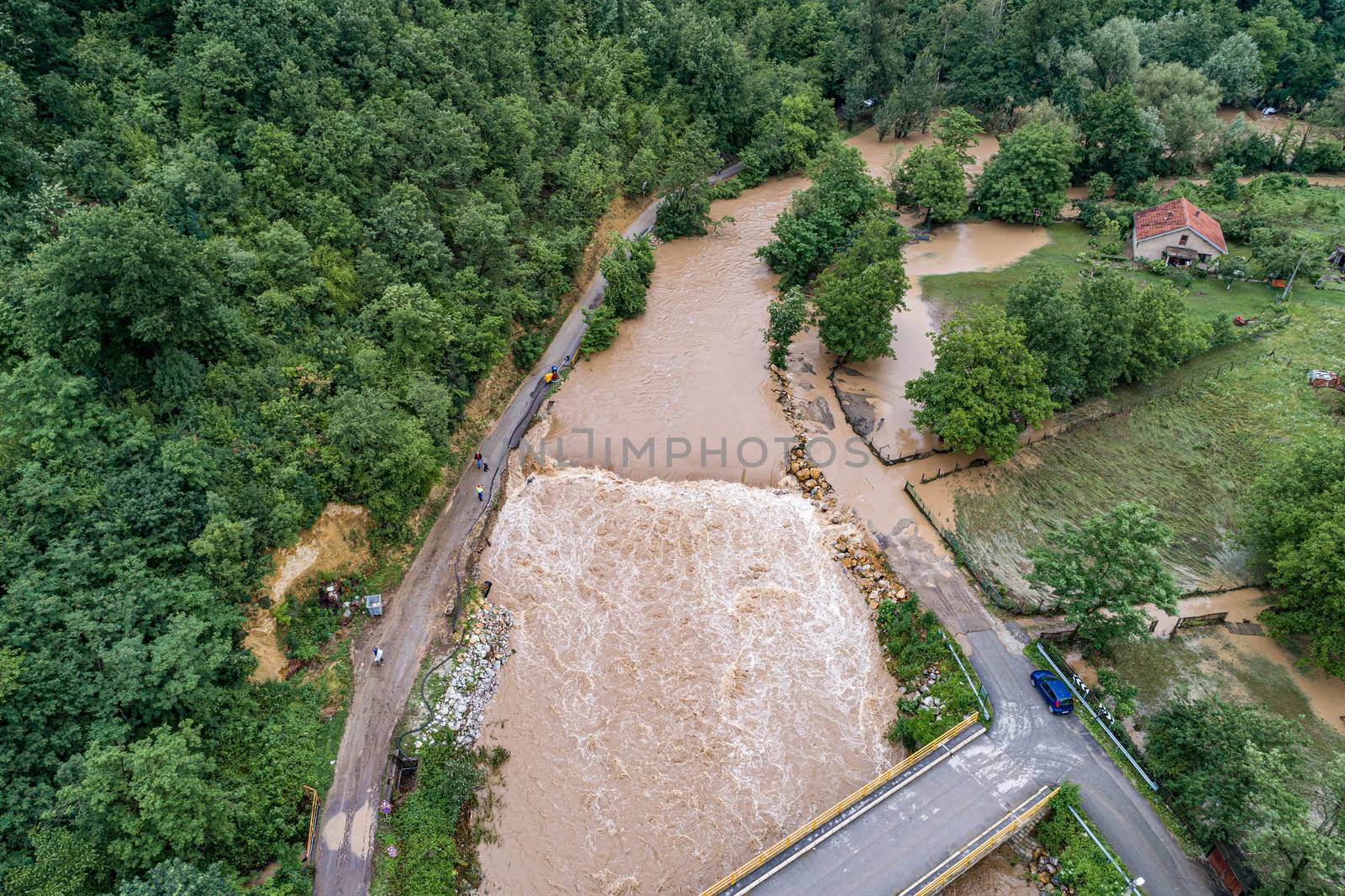 A river that overflows threatens the road bridge and property by adamr