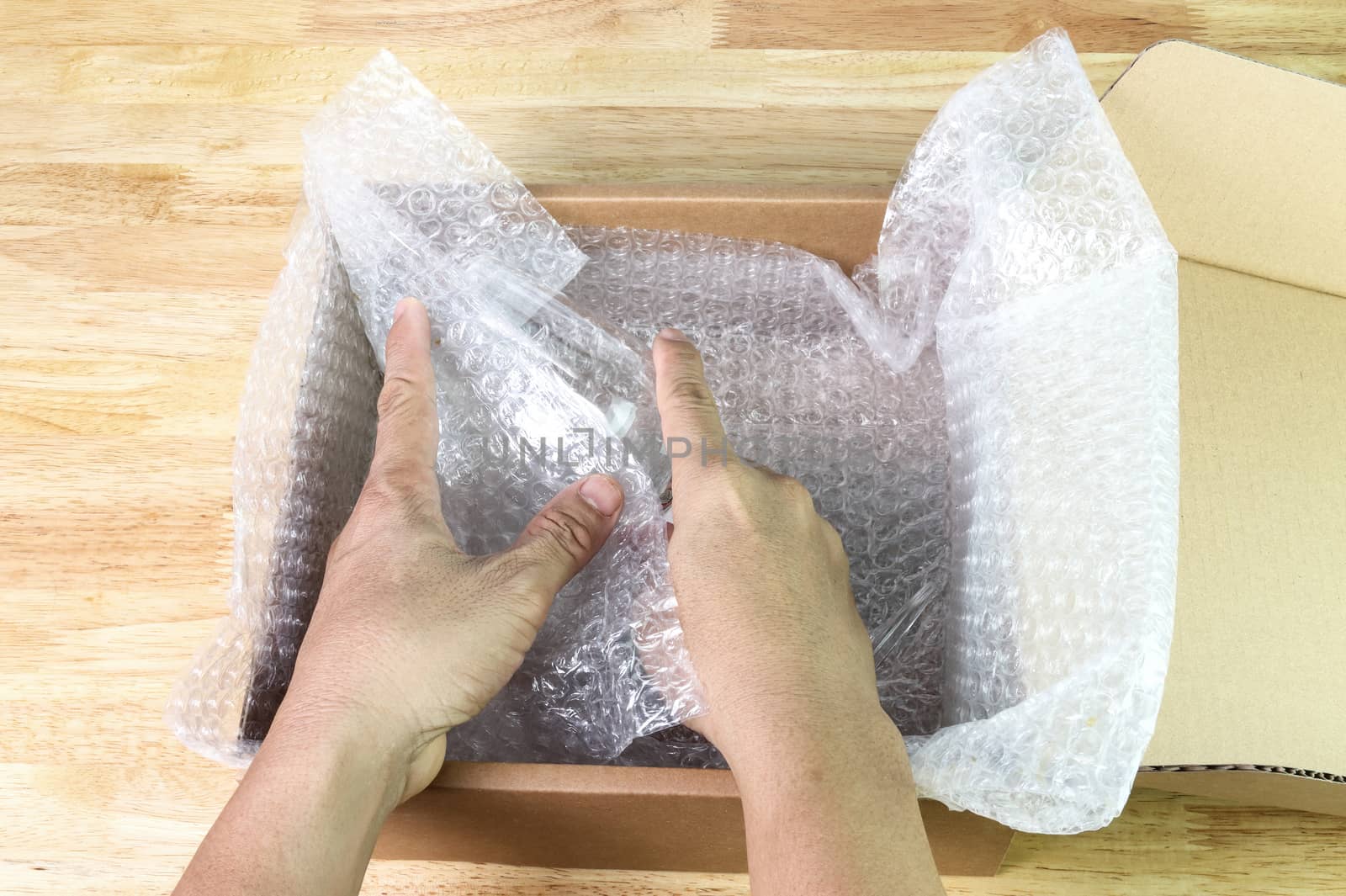 hand of man hold bubble wrap cover glass for protection product cracked or insurance During transit  