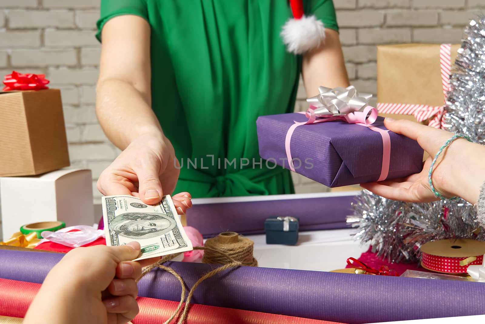 Paying for Gift Wrap at packing service with USA dollars banknotes. by PhotoTime
