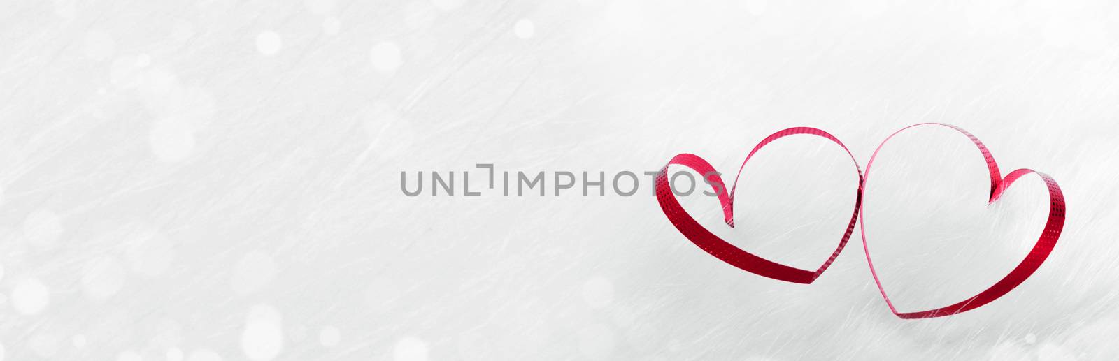 Red heart shaped ribbon on white fur background Valentines day design with copy space