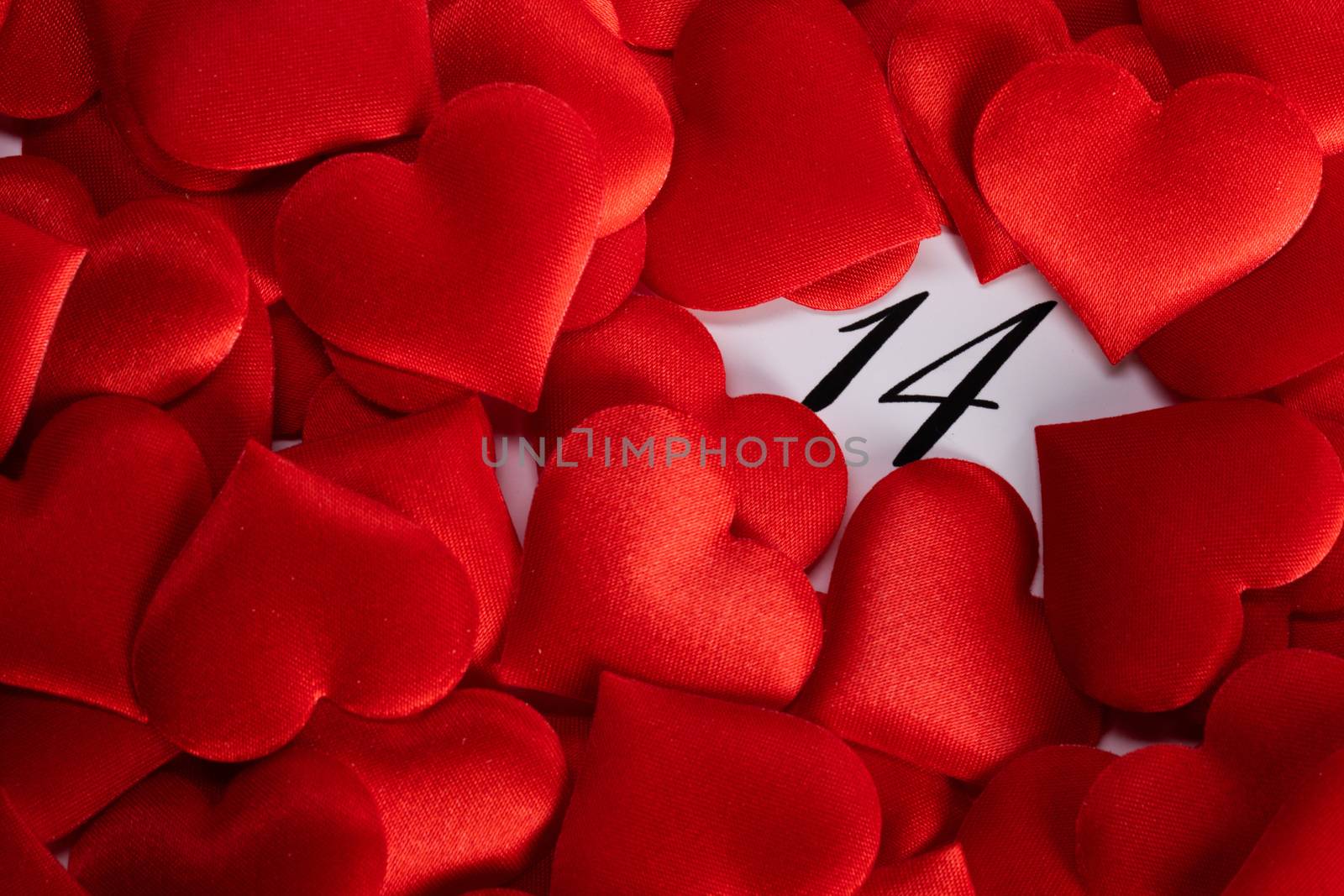 Valentine's day red silk hearts on calendar with 14 february date background, love, celebration concept
