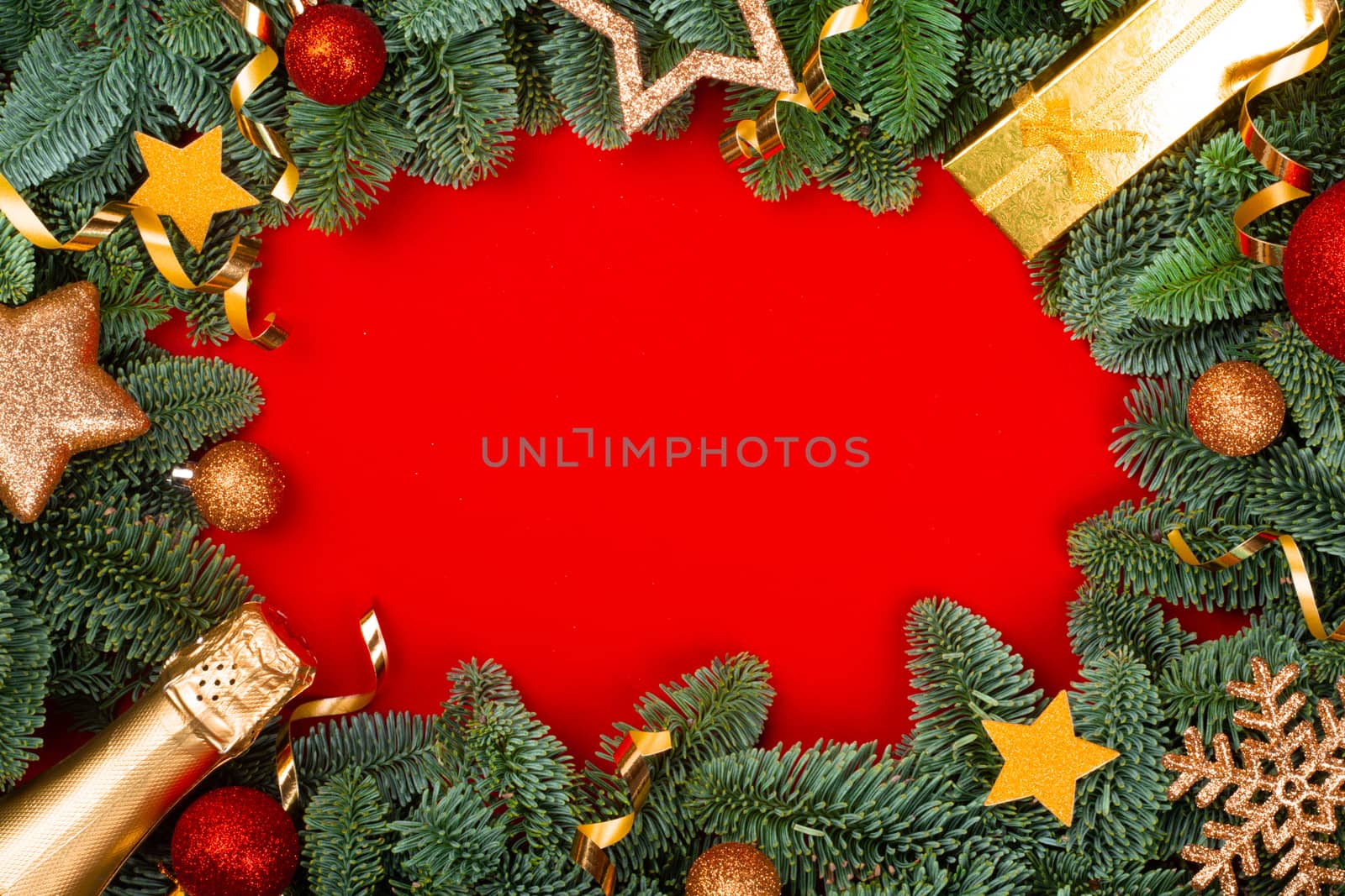 Christmas fir tree branches and baubles decor border frame on red background with copy space for text