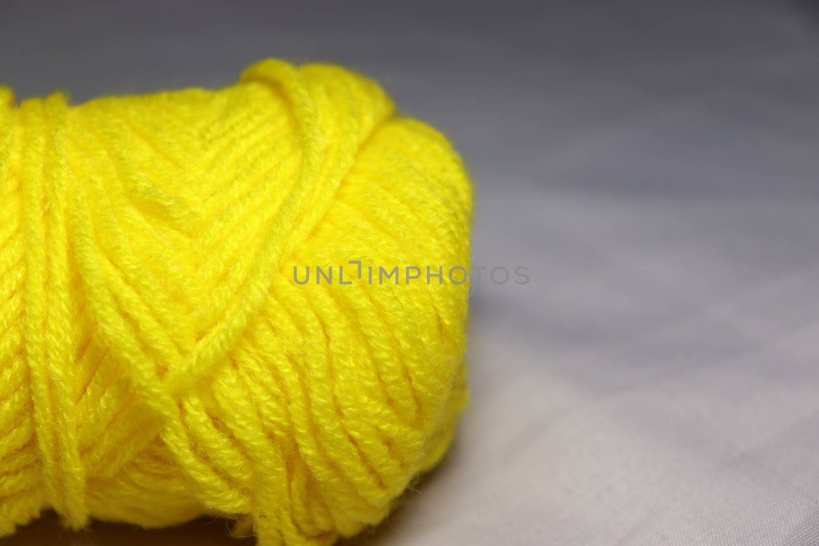 yellow colored yarn closeup on white background