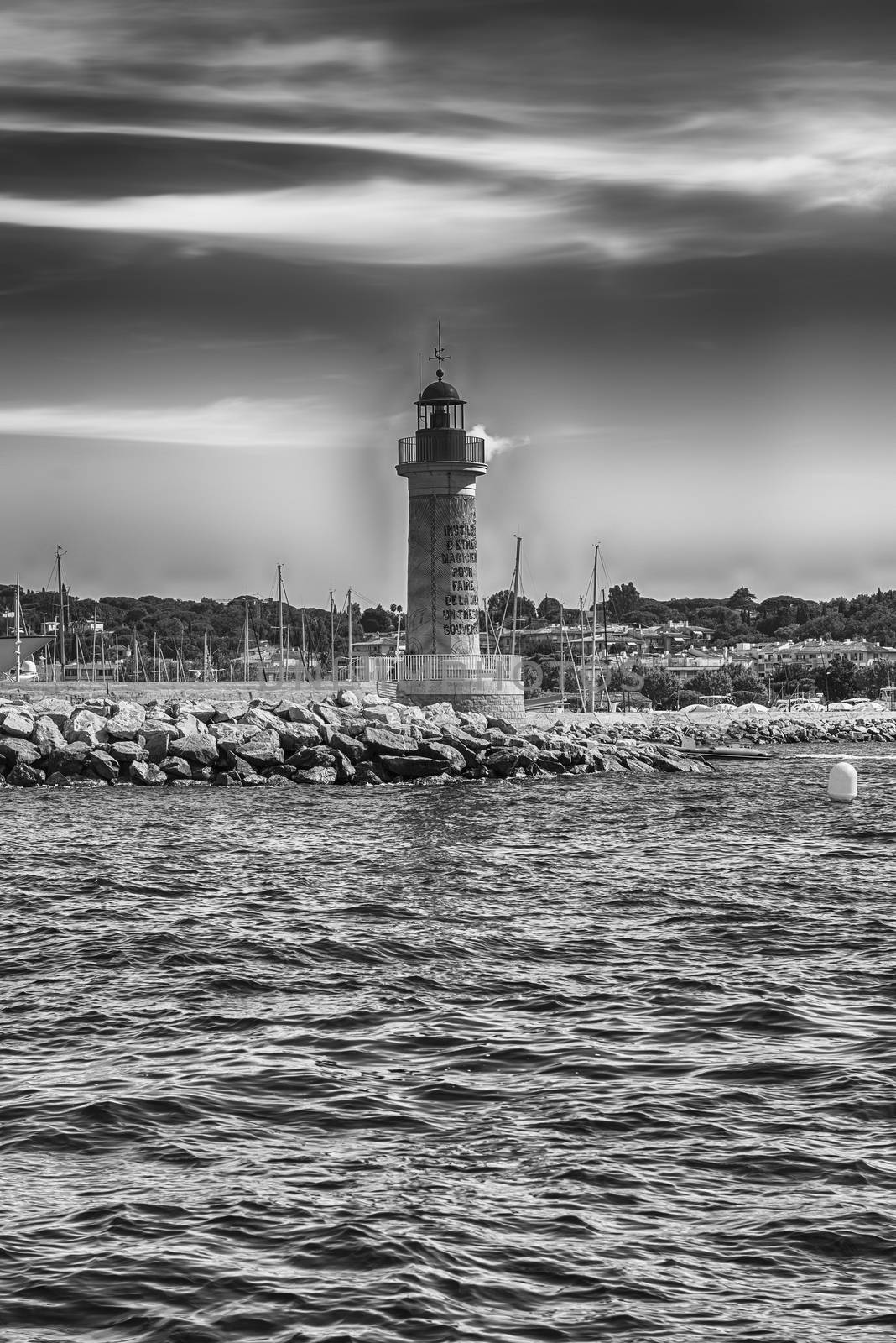 The iconic lighthouse in the harbor of Saint-Tropez, Cote d'Azur, France. The written reads 'no need to be a magician to make the sea a sovereign treasure'