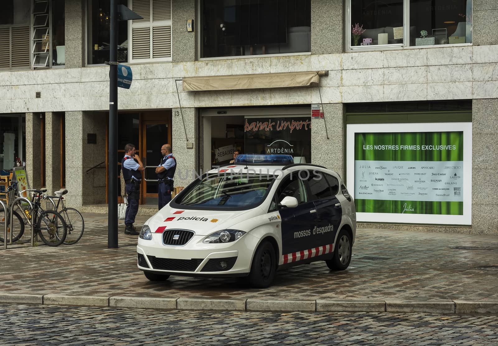 Police car and police on the streets of the city (Girona, Spain) by Grommik