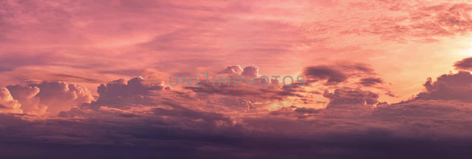 Panorama view red and purple sunset sky. Beautiful cloudscape in heaven sky. Nature background. Golden and dark fluffy clouds with sunlight. Beautiful clouds layer. Majestic sky for wallpaper. 