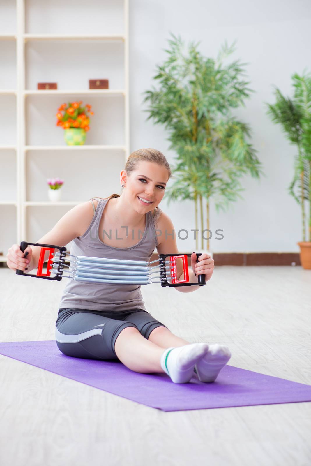 Young woman exercising with resistance band in gym