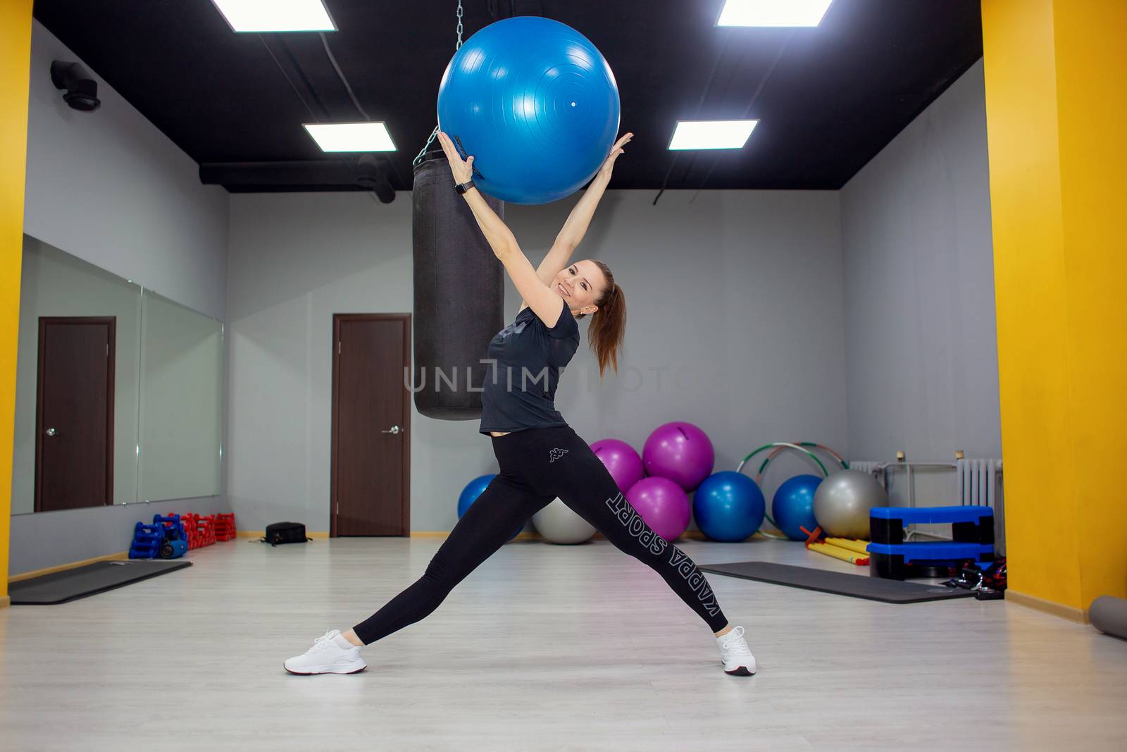 Russia, Volgograd, 03.17.2020 Beautiful woman doing fitness in the gym with a large gymnastic ball by borisenkoket