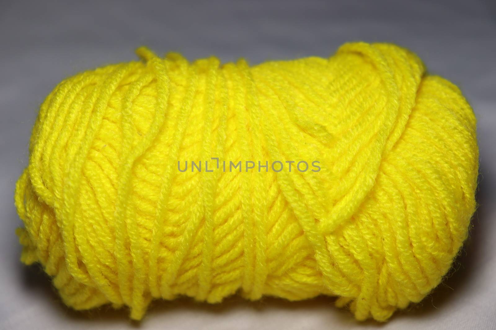 yellow colored yarn closeup on white background
