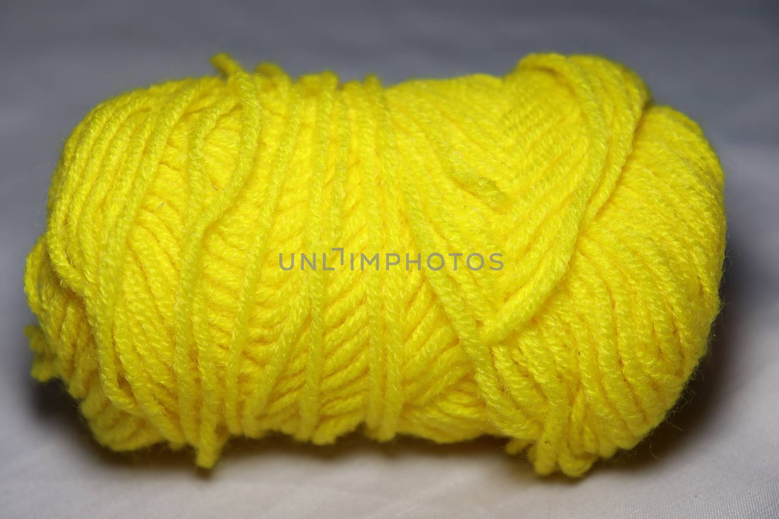 yellow colored yarn closeup on white background