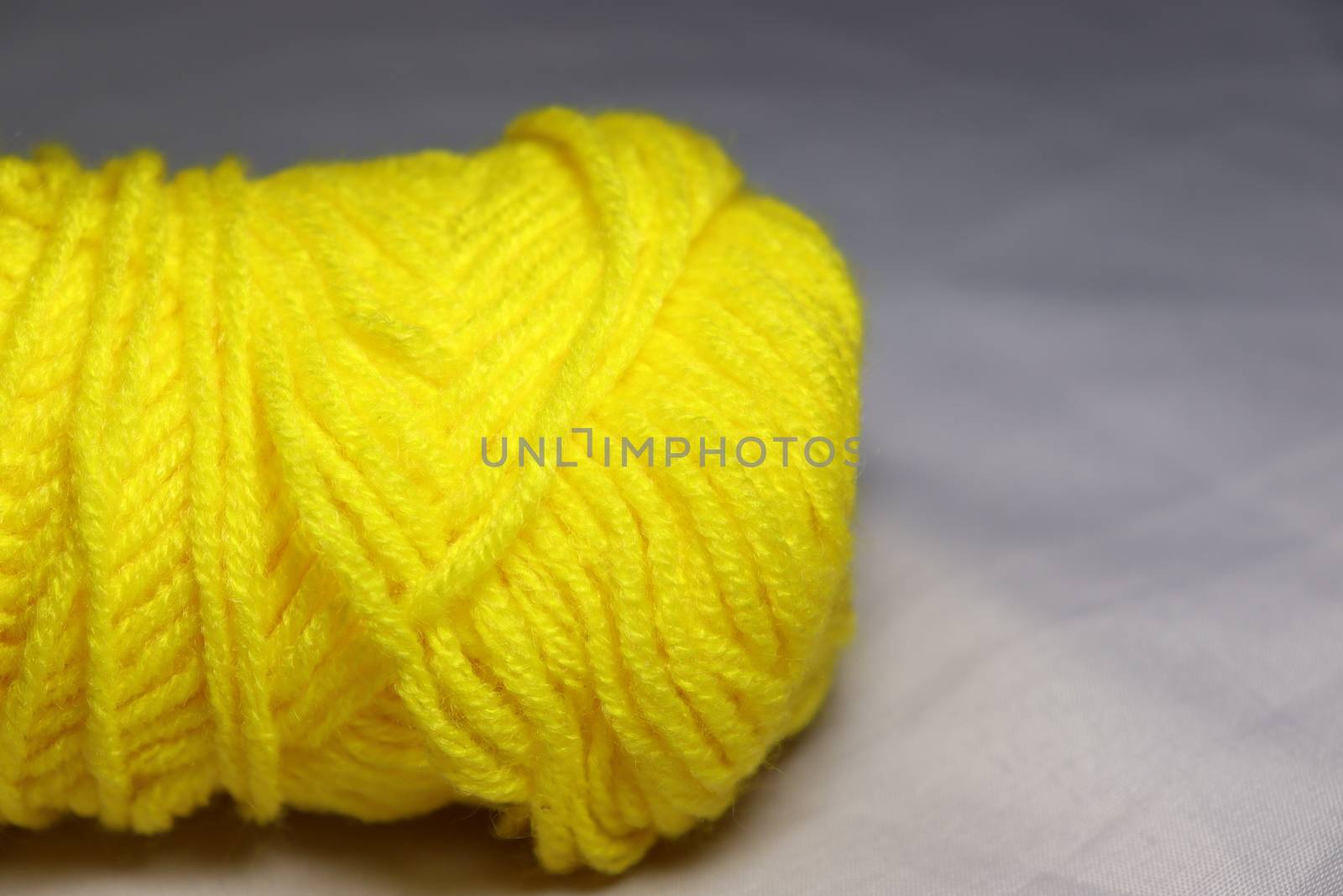 yellow colored yarn closeup on white background