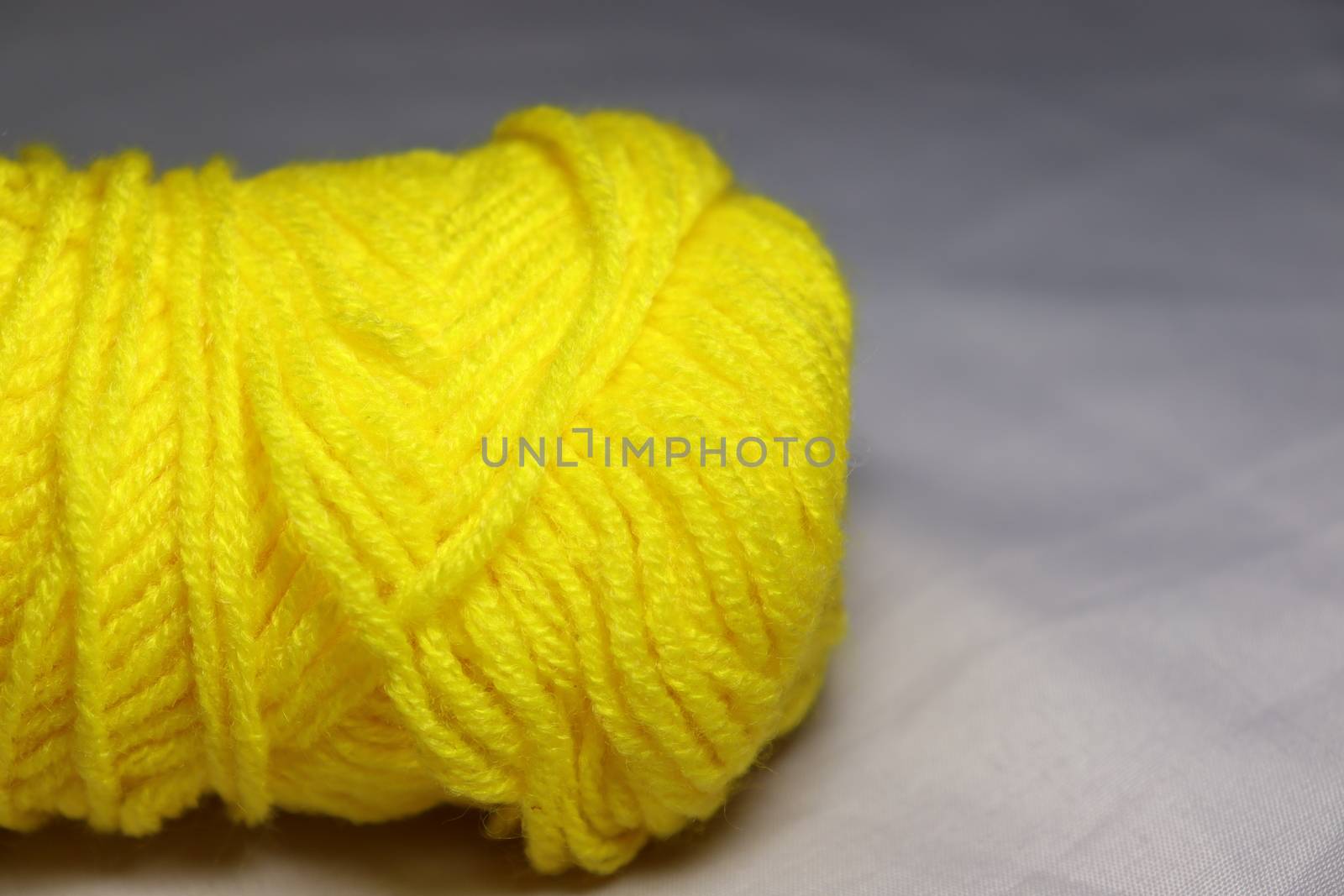 yellow colored yarn closeup on white background