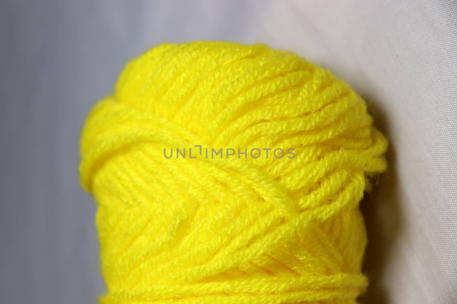 yellow colored yarn closeup on white background