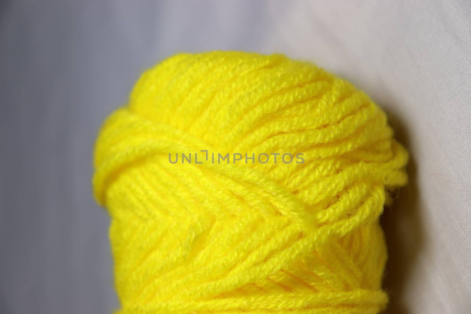 yellow colored yarn closeup on white background