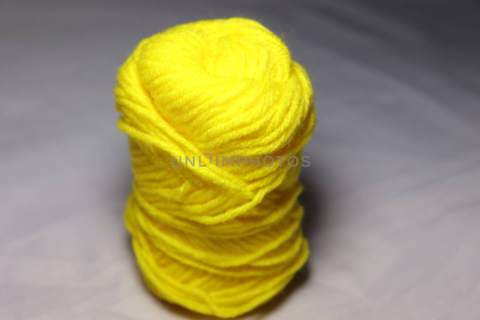 yellow colored yarn closeup on white background