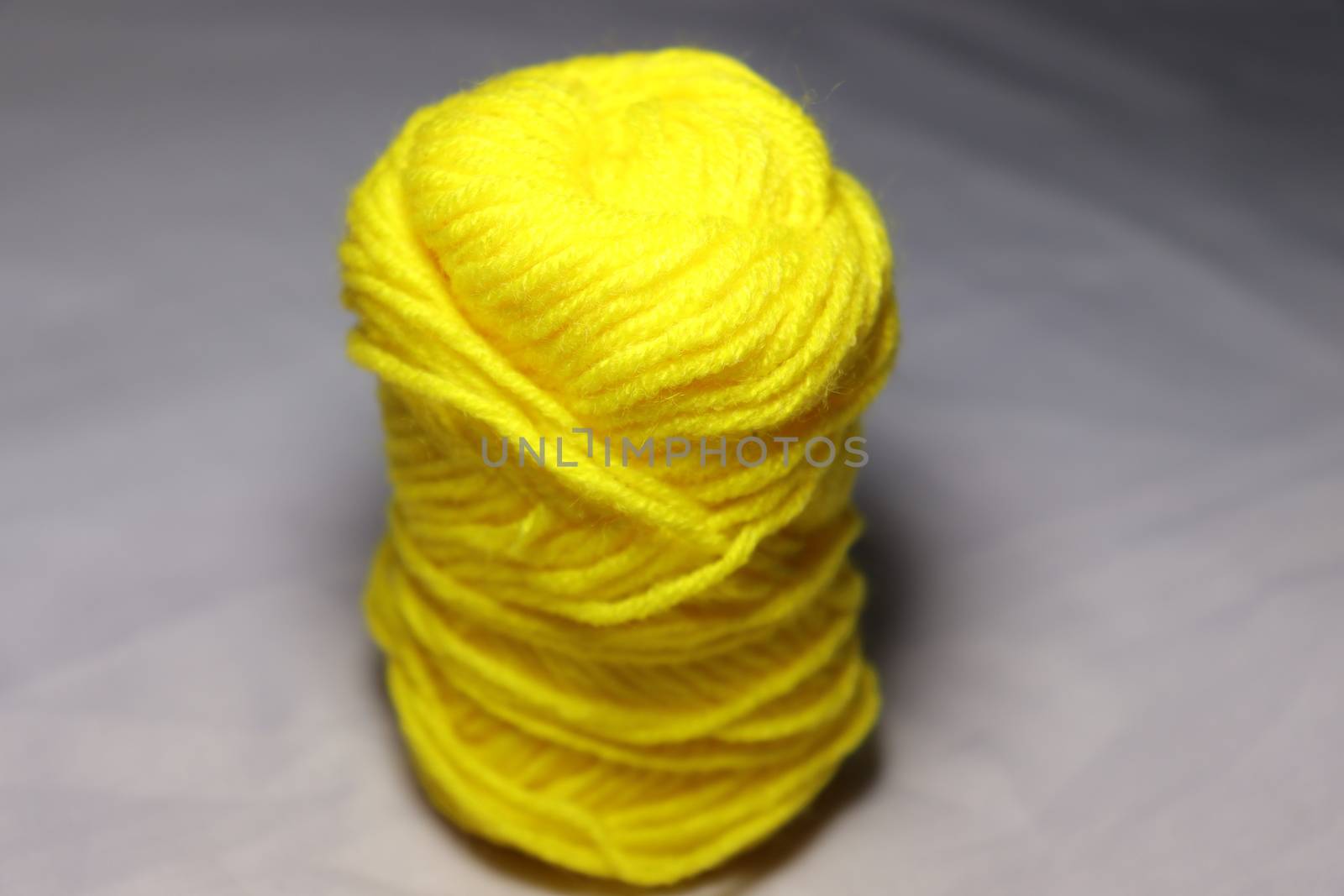 yellow colored yarn closeup on white background