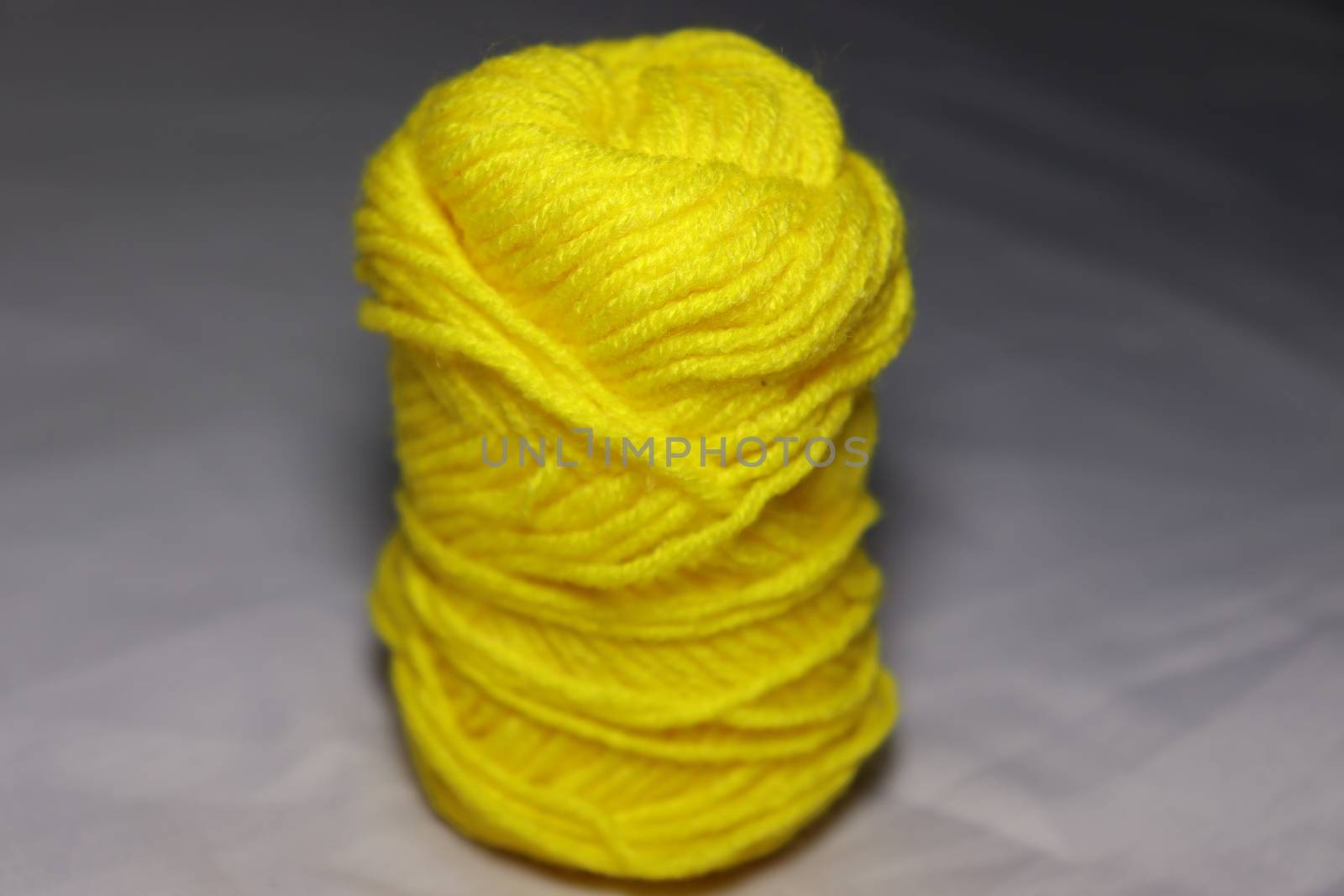 yellow colored yarn closeup on white background