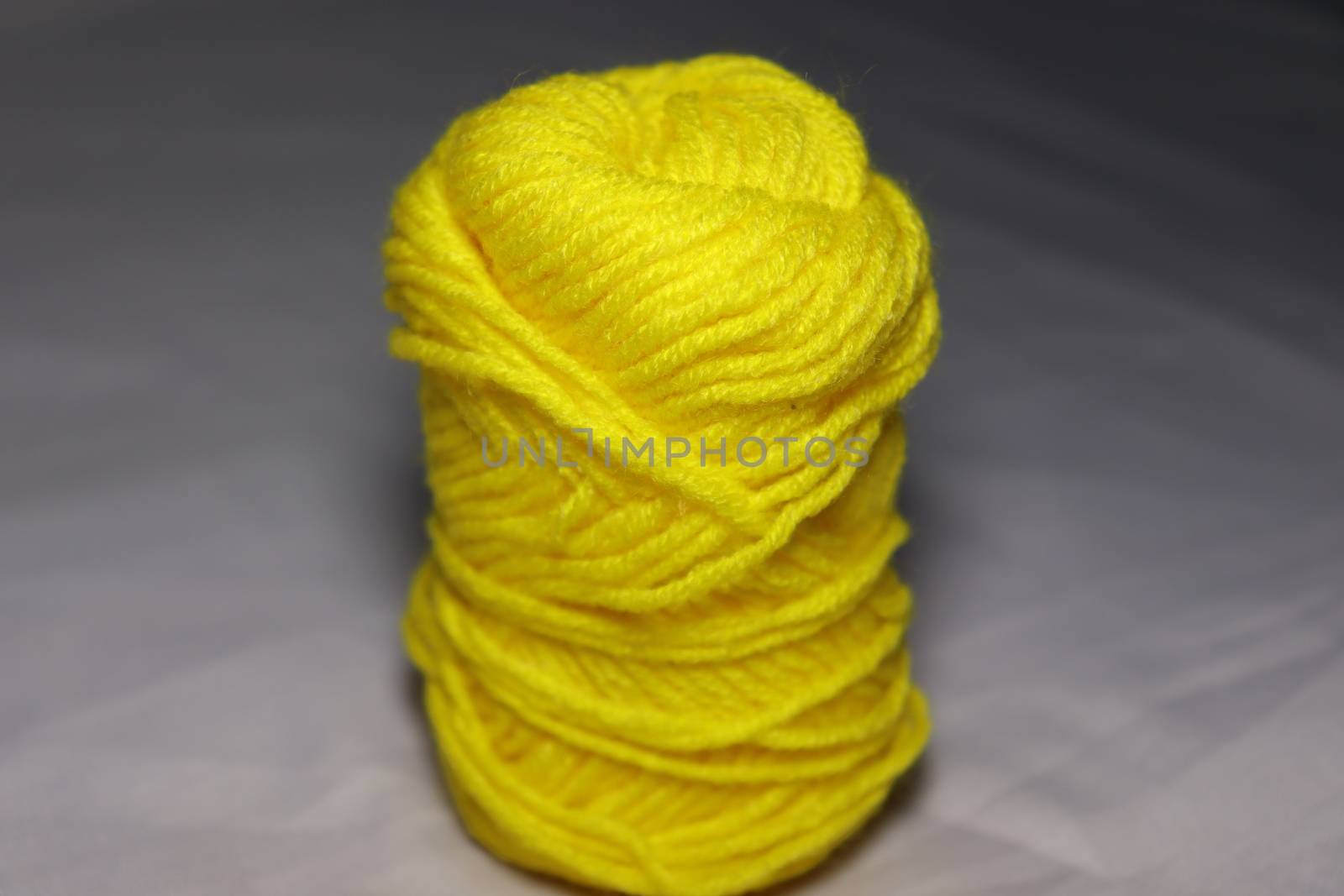 yellow colored yarn closeup on white background