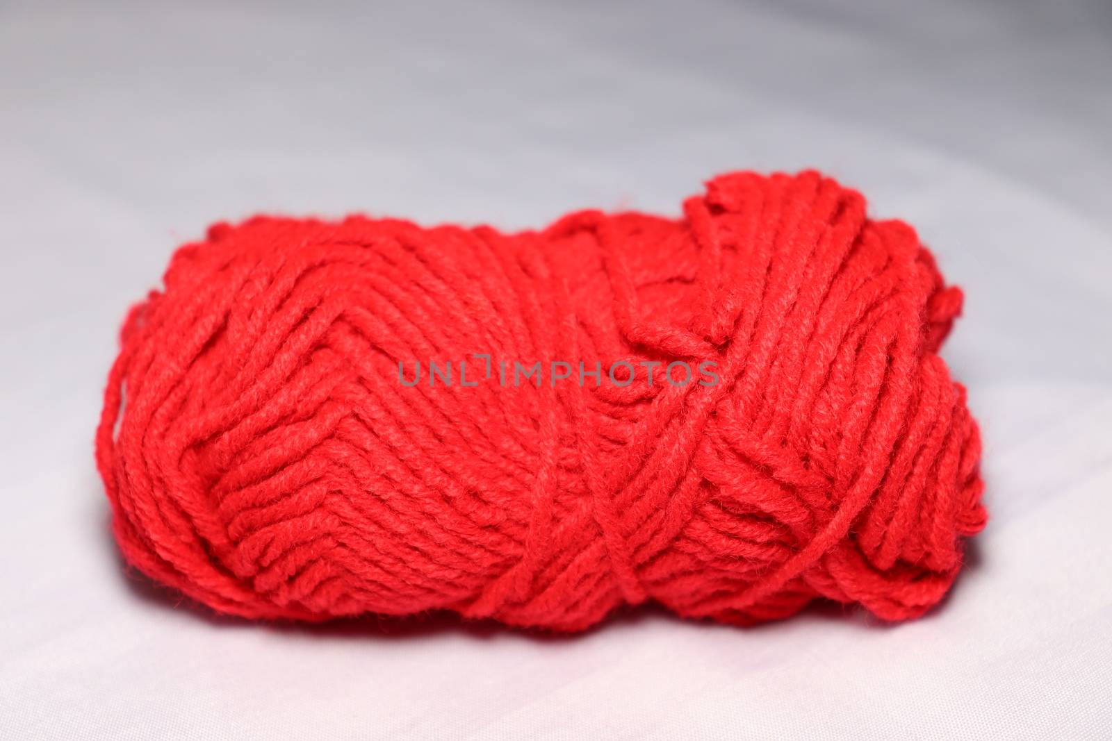 red colored yarn closeup on white background