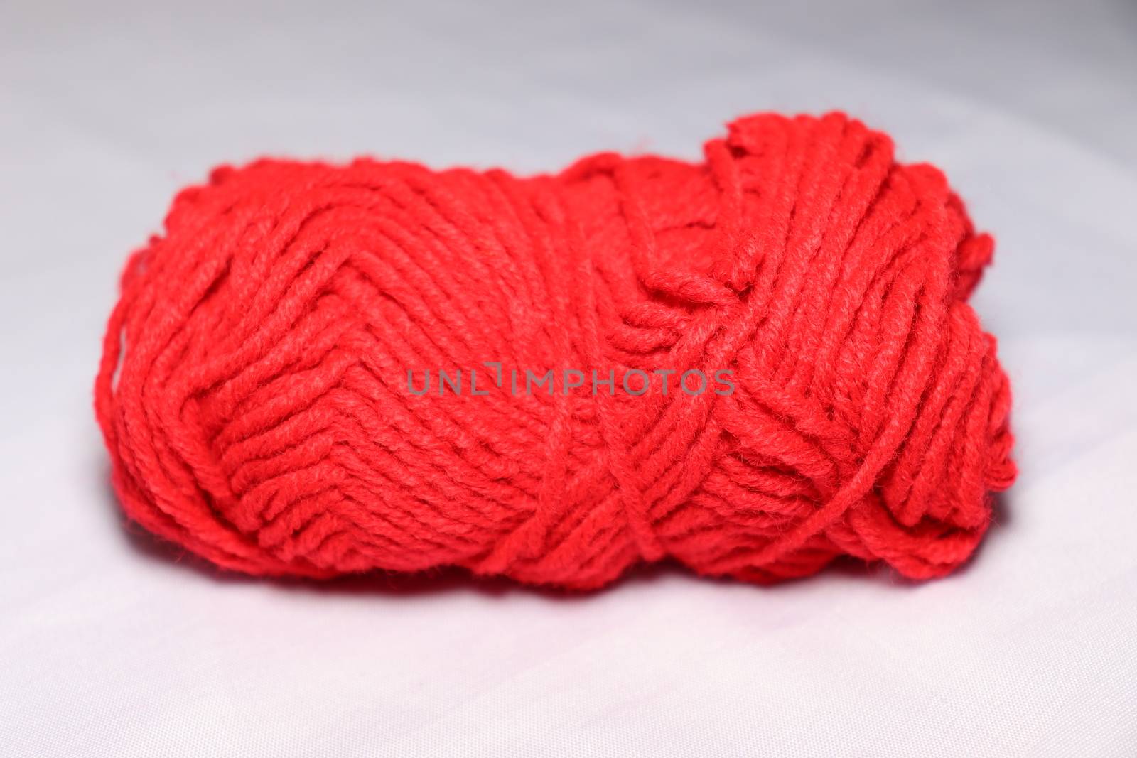 red colored yarn closeup on white background