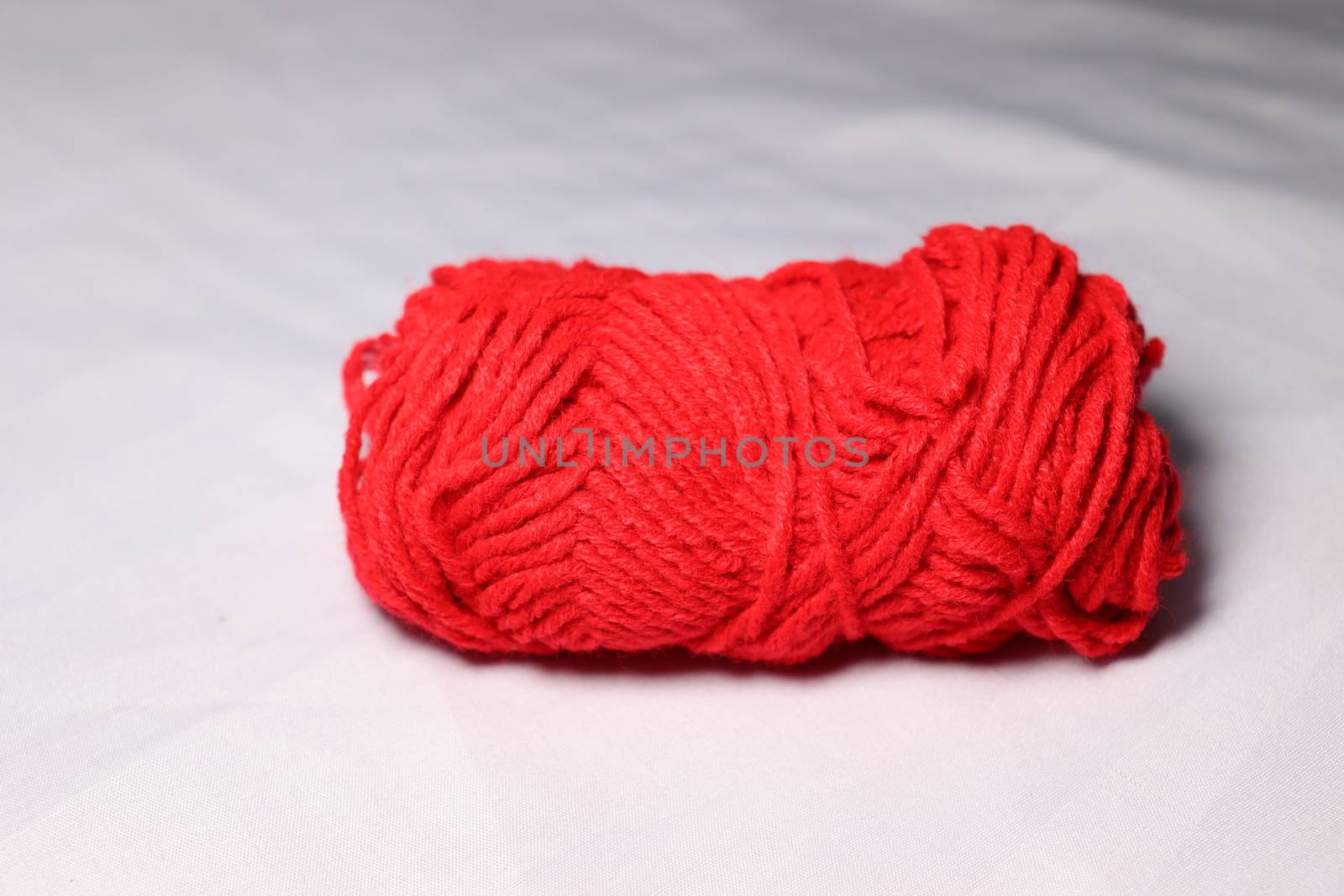 red colored yarn closeup on white background