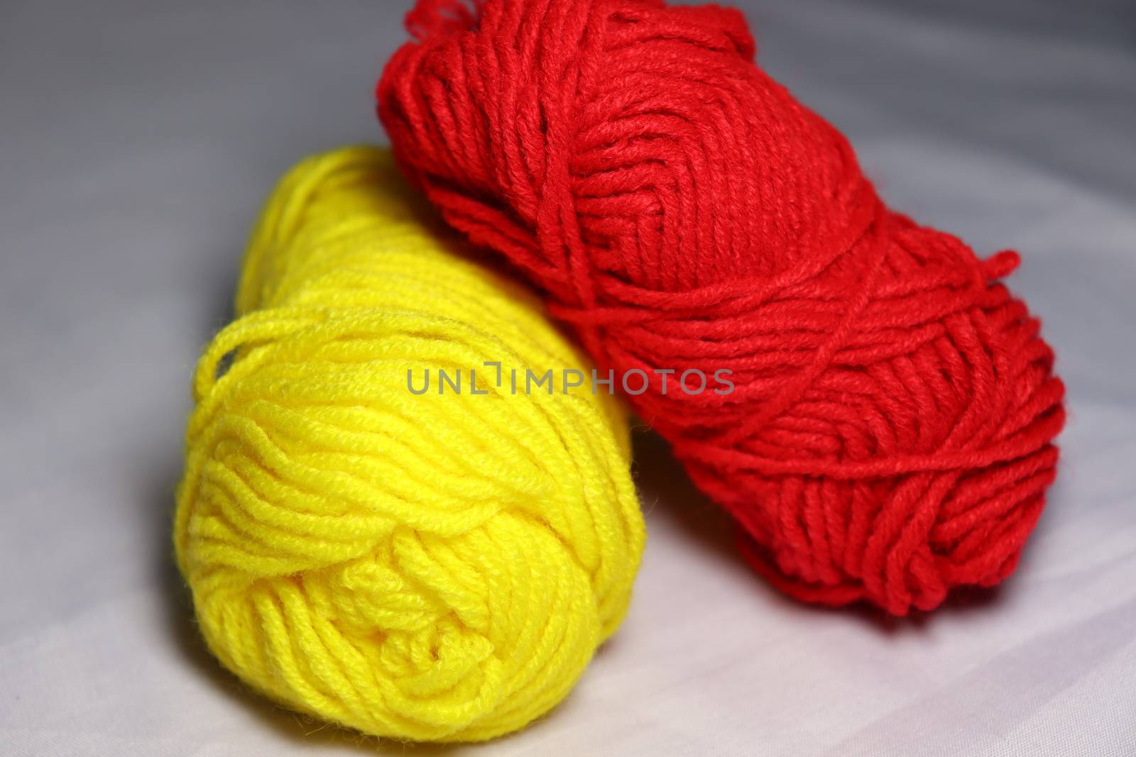 red and yellow colored yarn closeup on white background