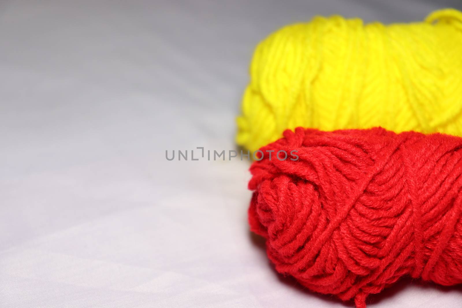 red and yellow colored yarn closeup on white background