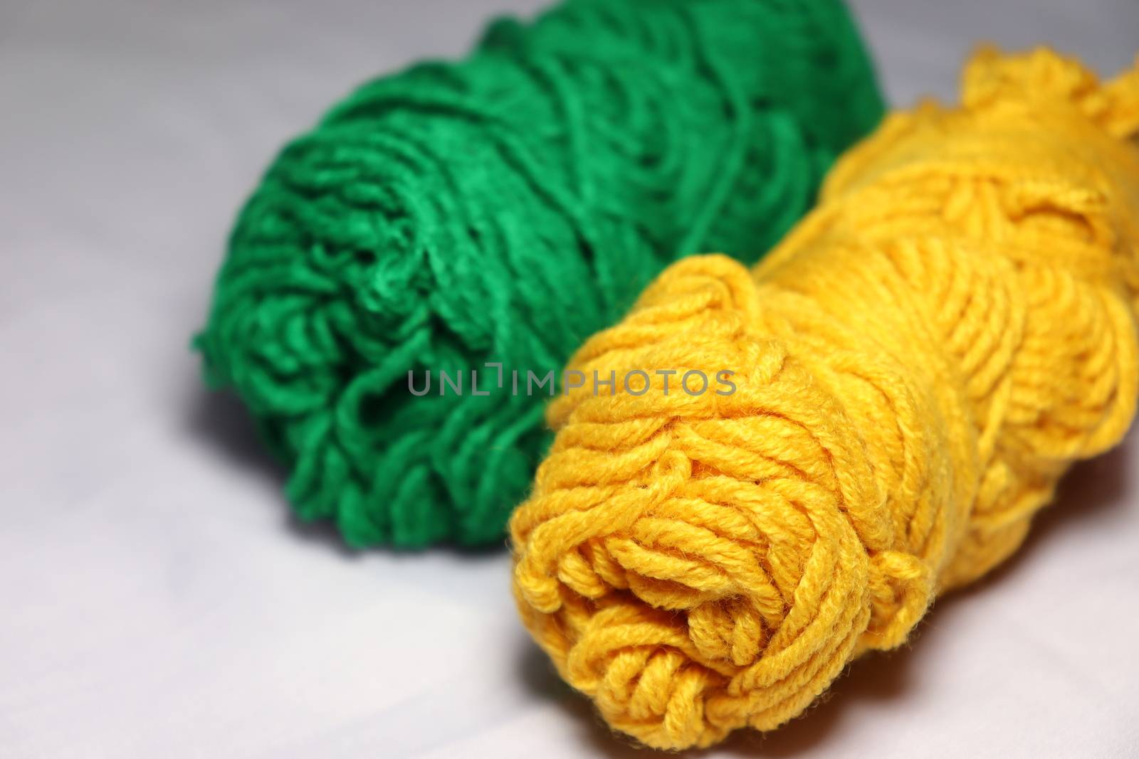 green and yellow colored yarn closeup on white background
