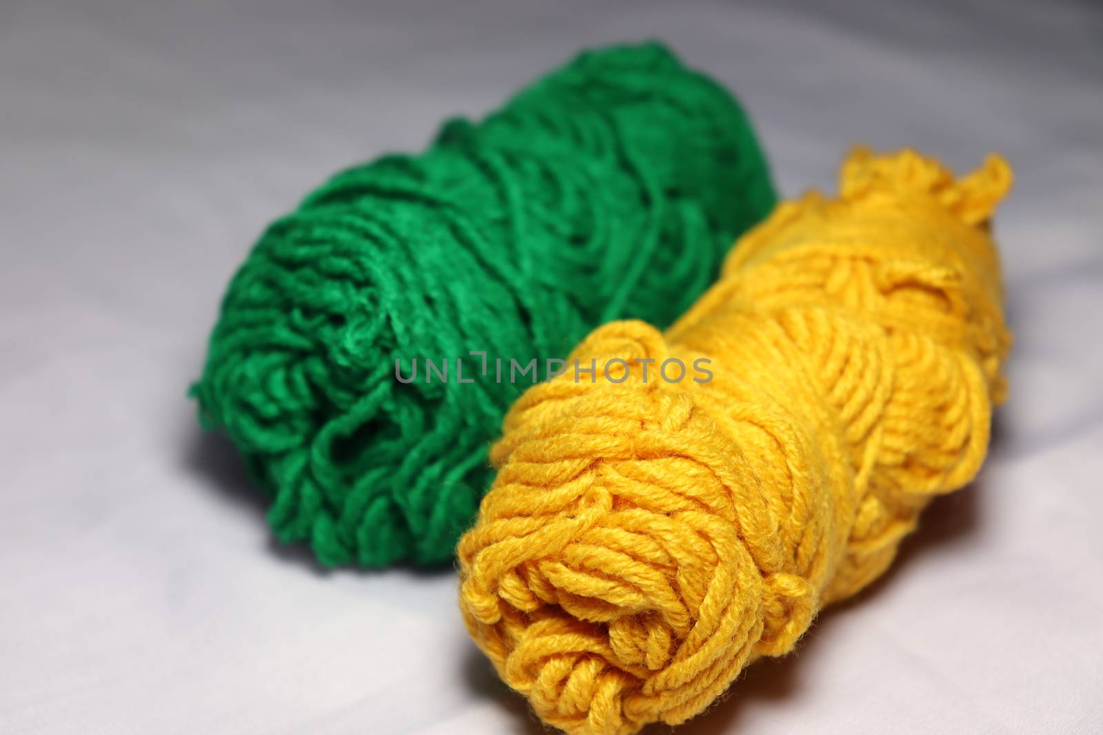 green and yellow colored yarn closeup on white background