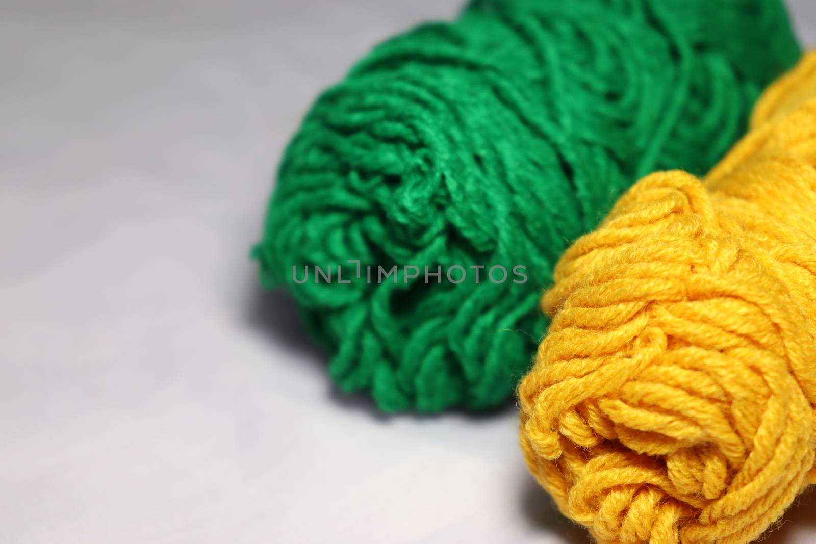 green and yellow colored yarn closeup on white background