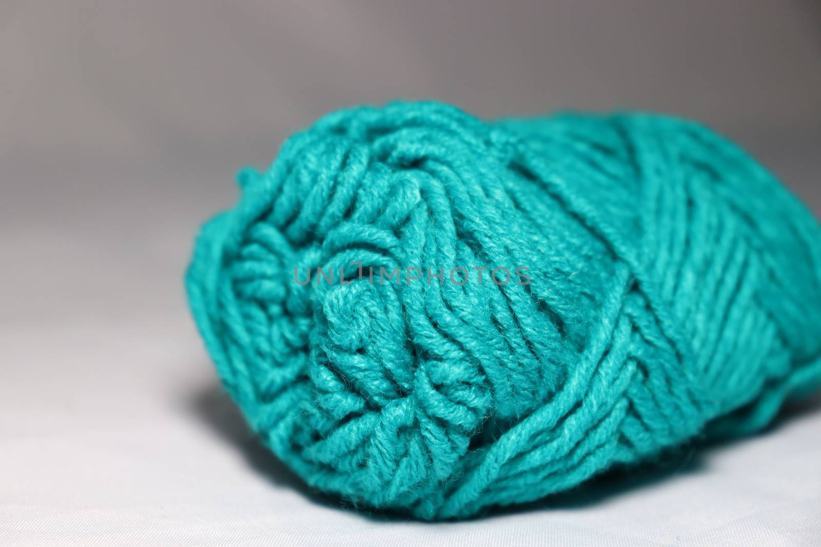 cyan colored yarn closeup on white background