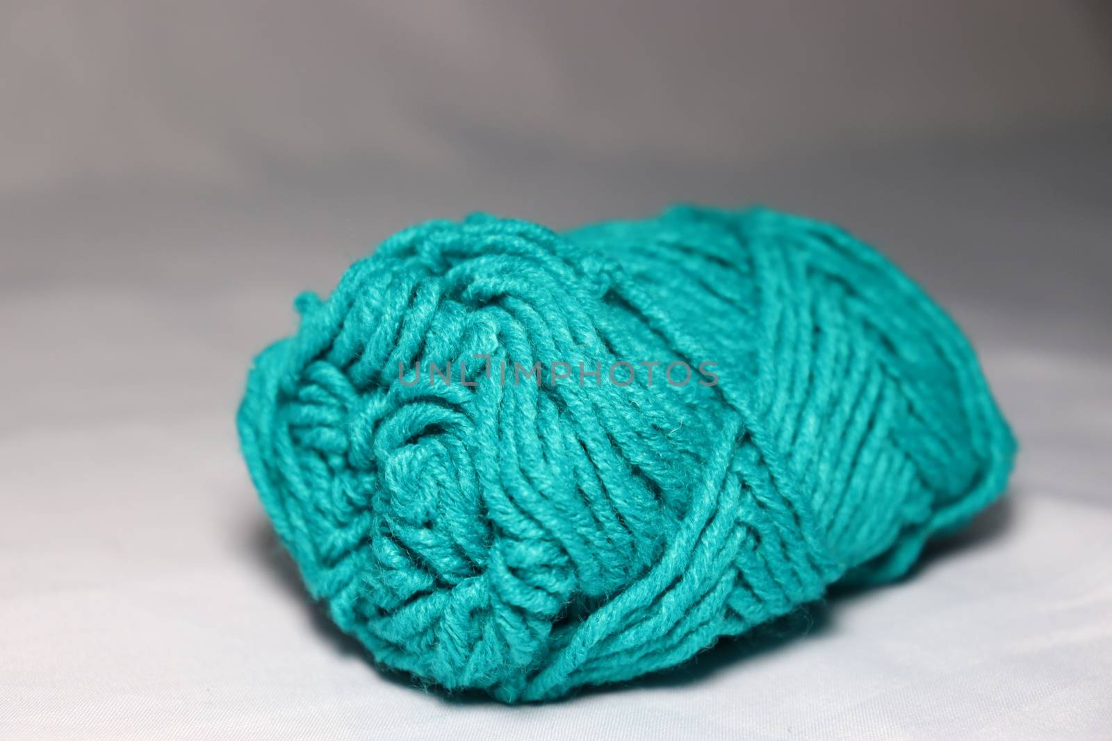 cyan colored yarn closeup on white background