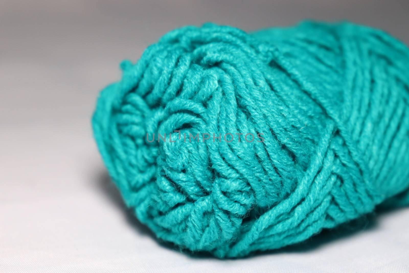 cyan colored yarn closeup on white background