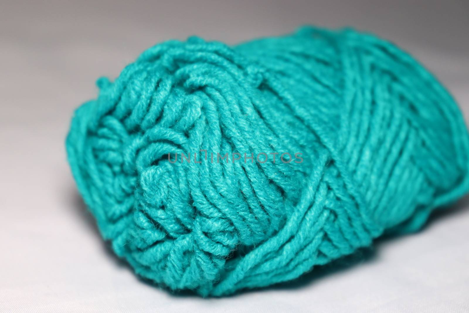 cyan colored yarn closeup on white background