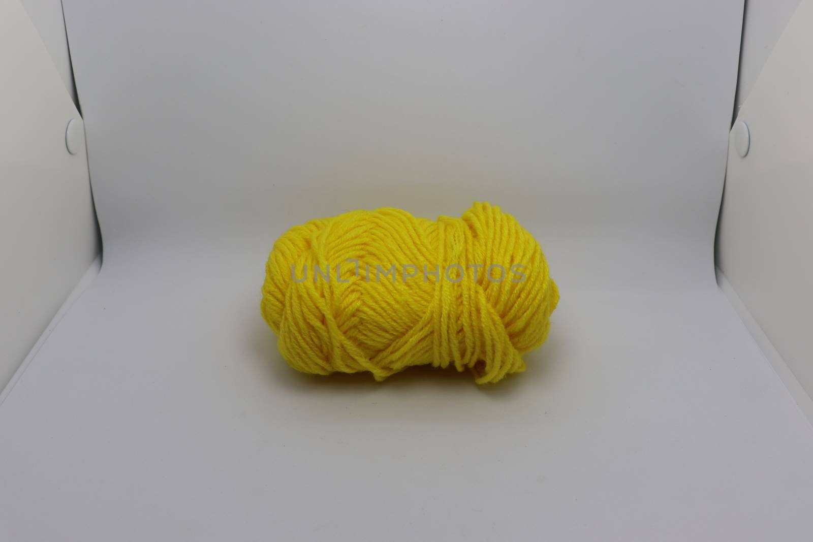 yellow colored yarn closeup on white background