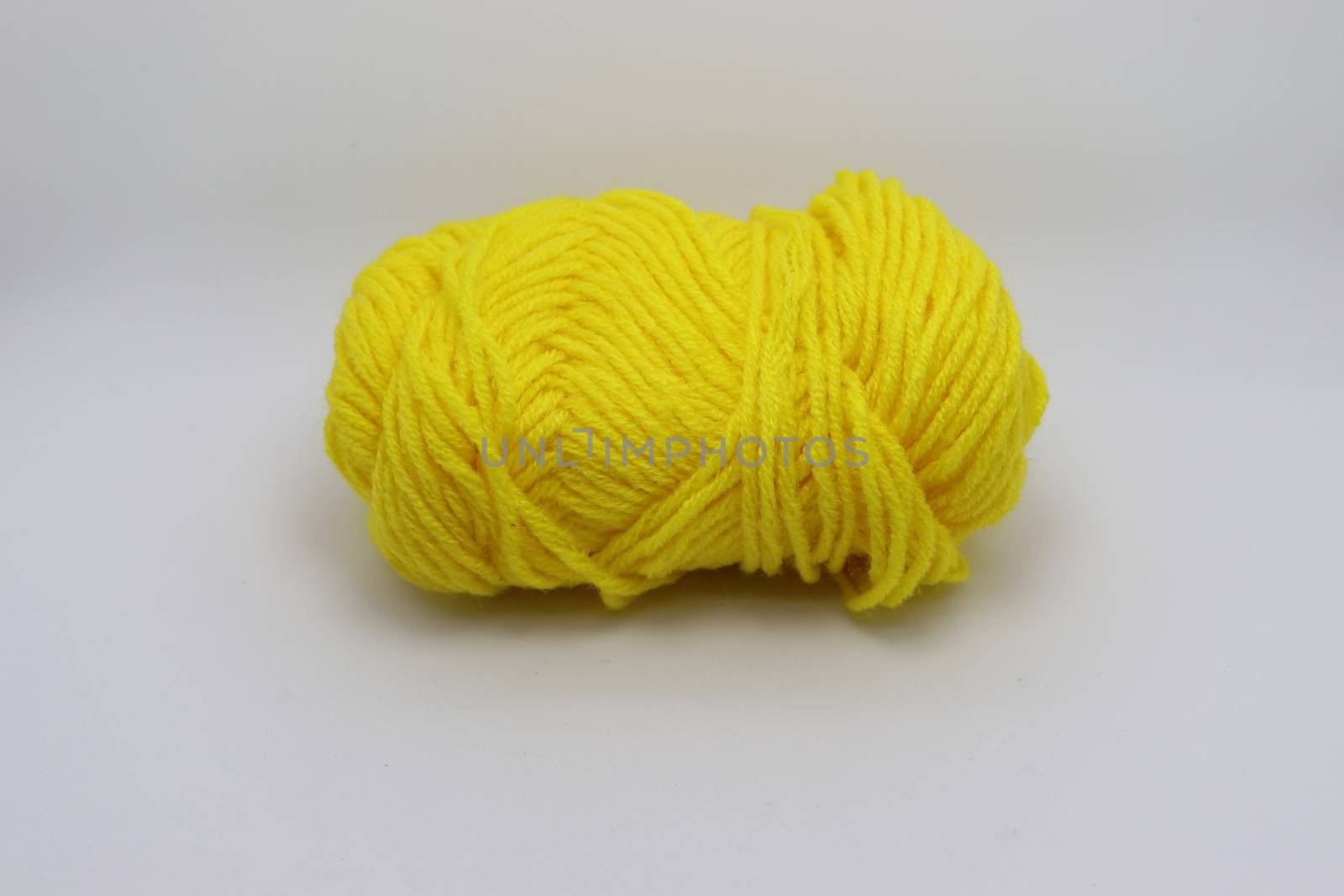 yellow colored yarn closeup on white background