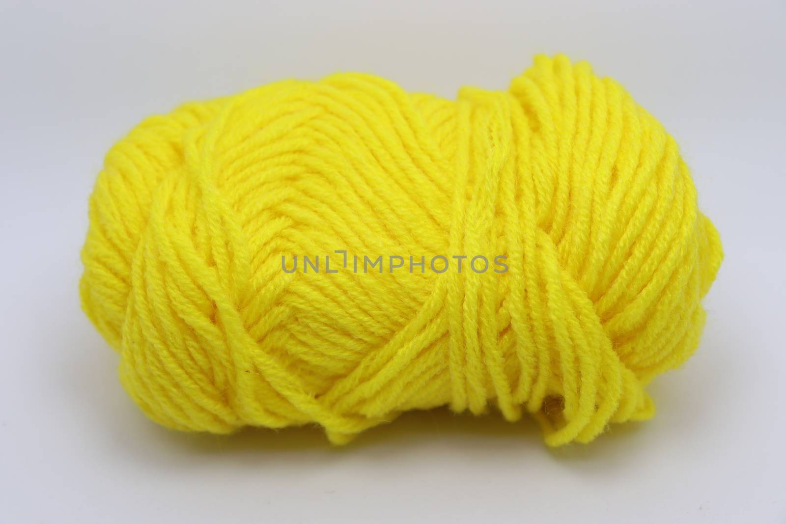 yellow colored yarn closeup on white background