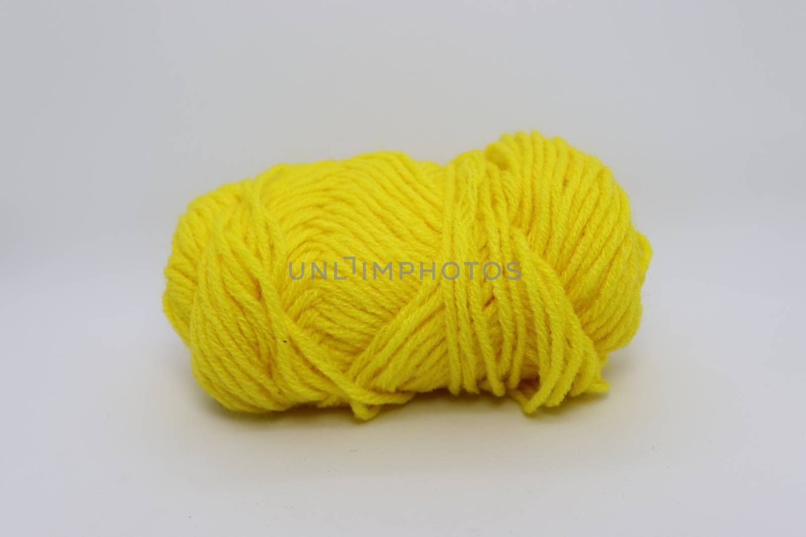 yellow colored yarn closeup on white background