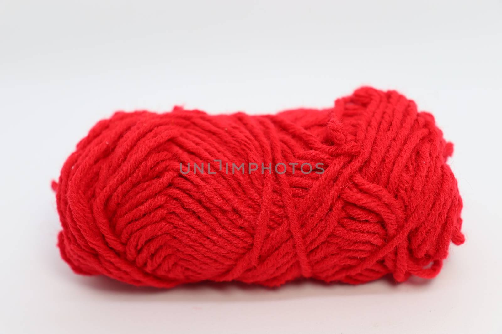 red colored yarn closeup on white background