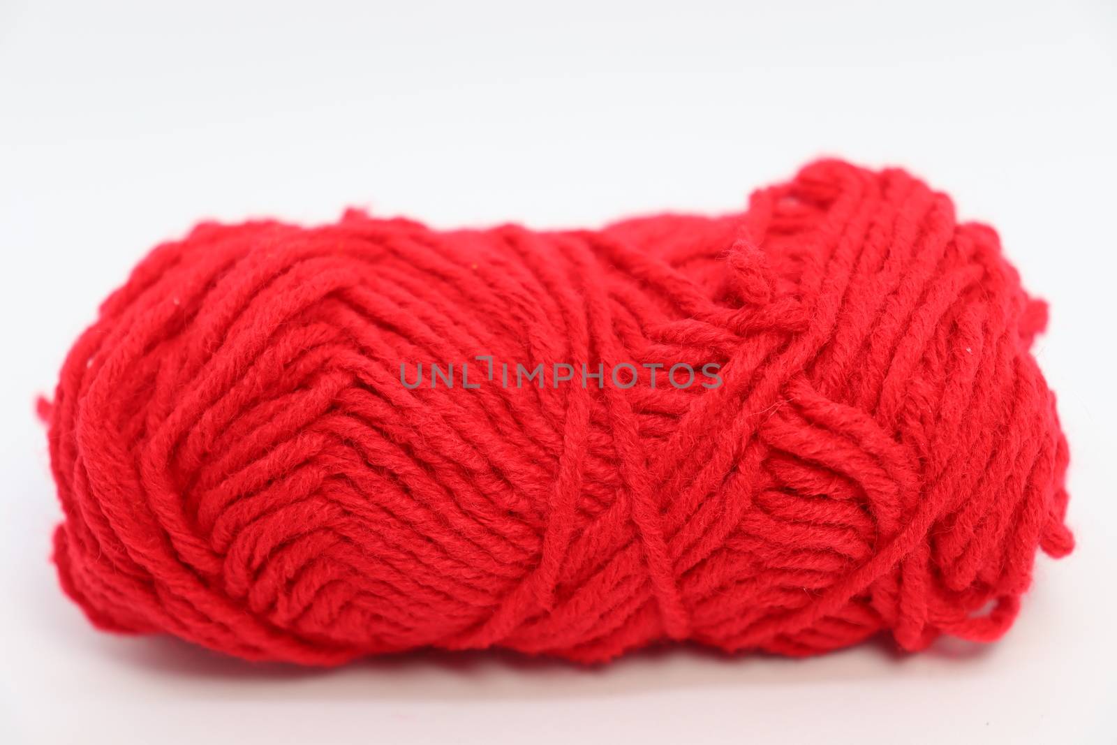 red colored yarn closeup on white background