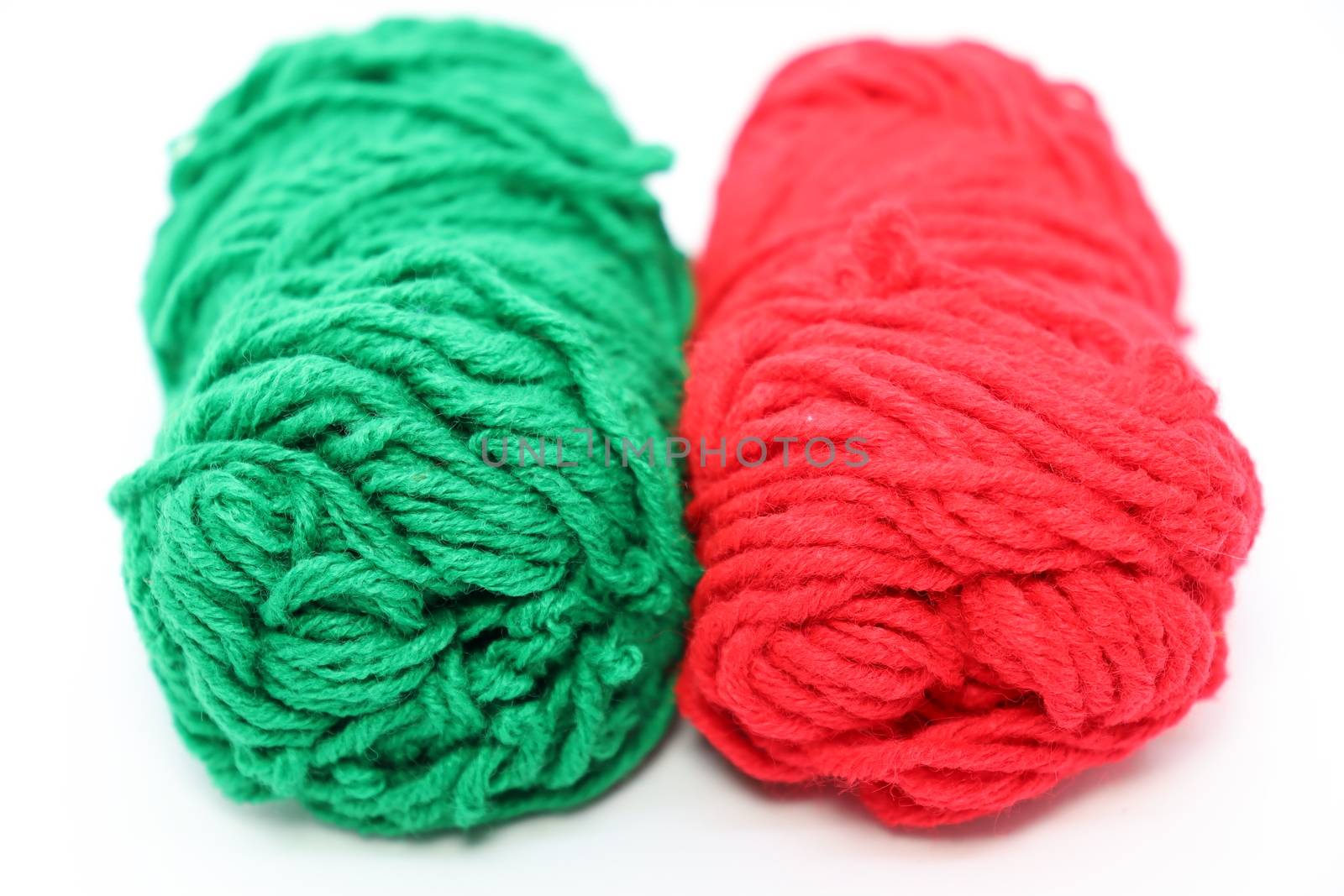 red and green colored yarn closeup on white background