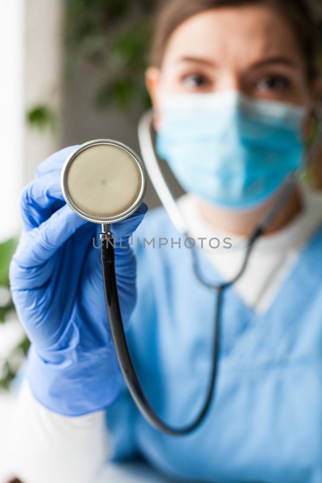 Caucasian female doctor holding a stethoscope, listening to patient body for sounds made by heart, lungs, intestines, measuring blood pressure, diagnostic and therapy, prevention and healthy lifestyle
