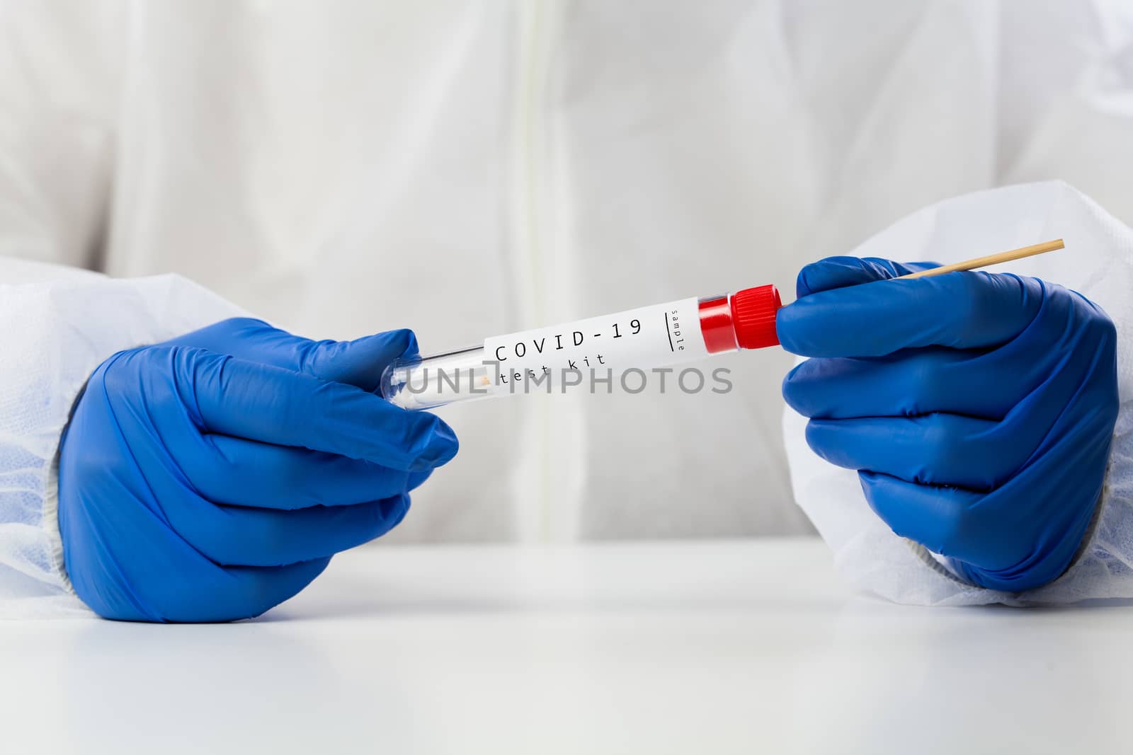Lab technician holding swab collection kit by Plyushkin